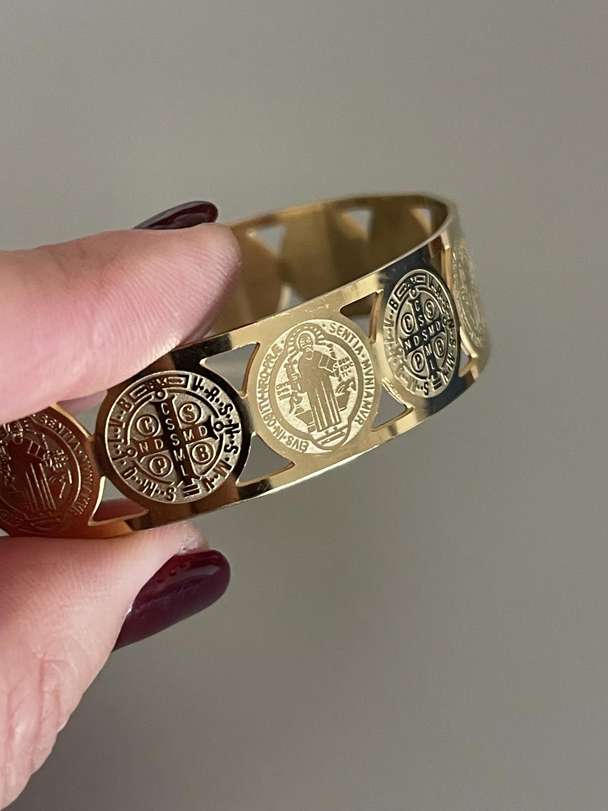 Pulsera Hippie Chic religiosa de acero inoxidable dorado con lindas imagenes de San Benito y cruz. Diametro 6.5 c.