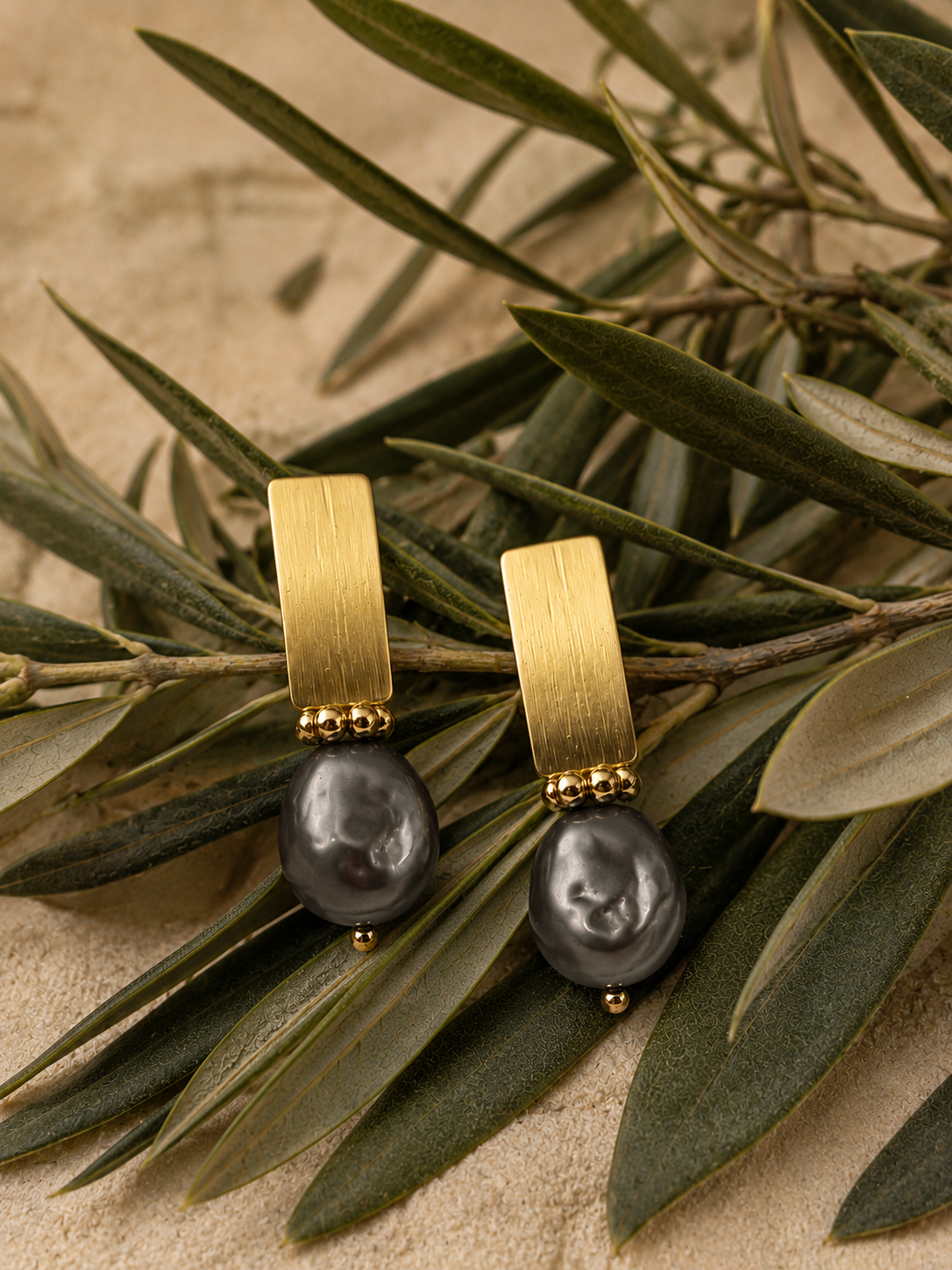 Aros Hippie Chic bañados en oro con maravillosa perla natural de agua dulce negra gris azulada. Largo 3 cm.