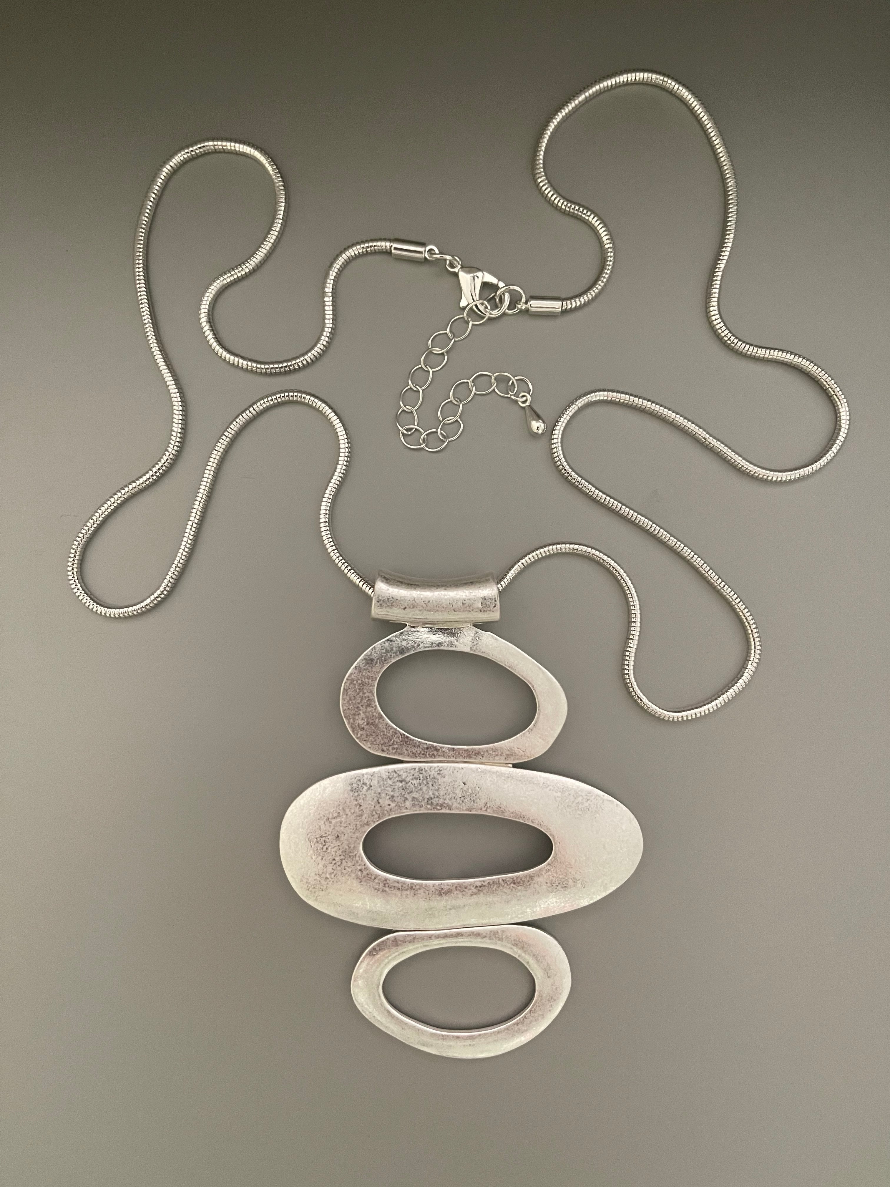 Collar Hippie Chic largo con un elegante acabado opaco y colgante de tres circulos ovalados.