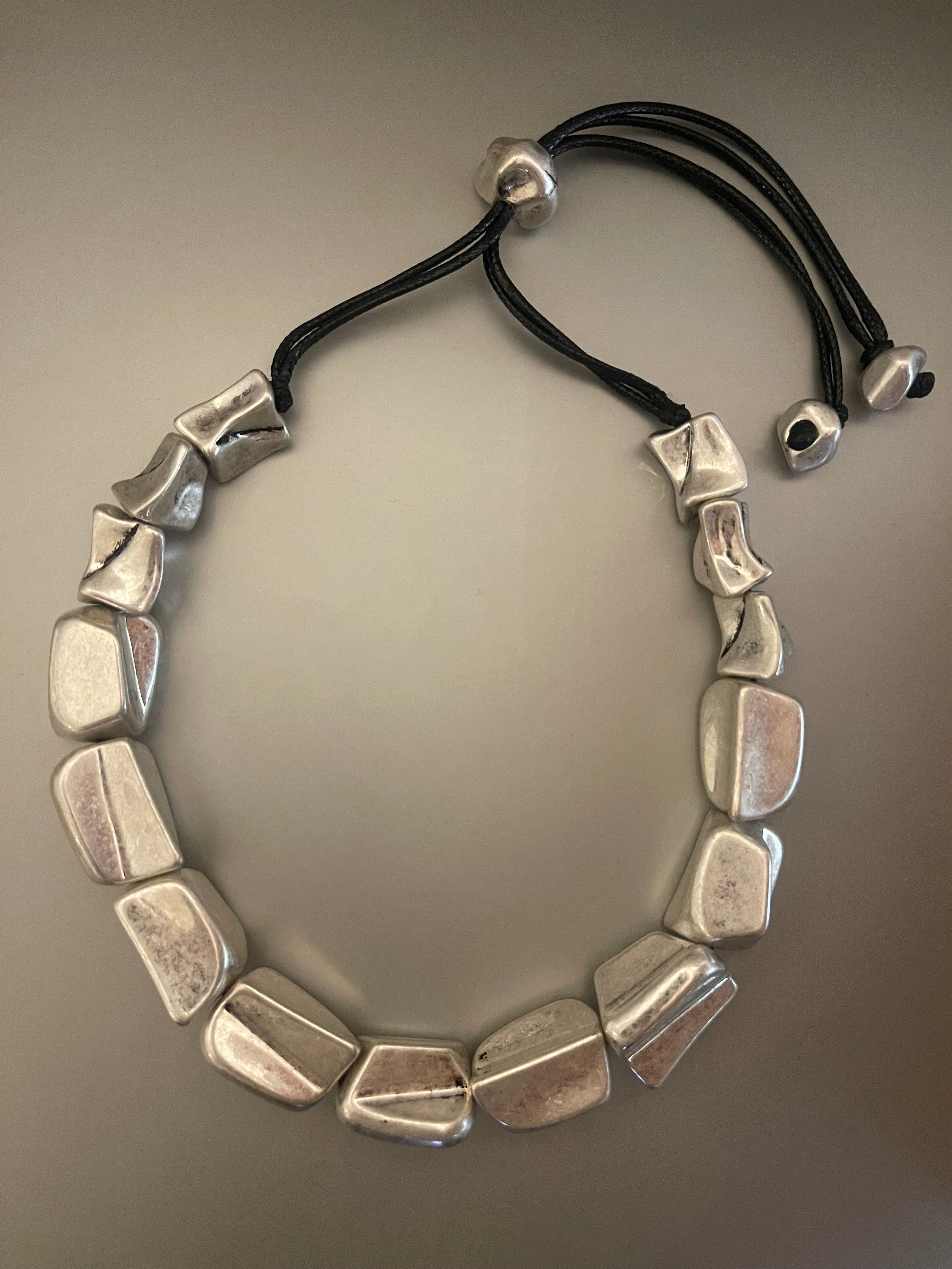 Collar Hippie Chic corto ajustable con preciosas figuras en acrilico plateado. Largo total 74 cm.