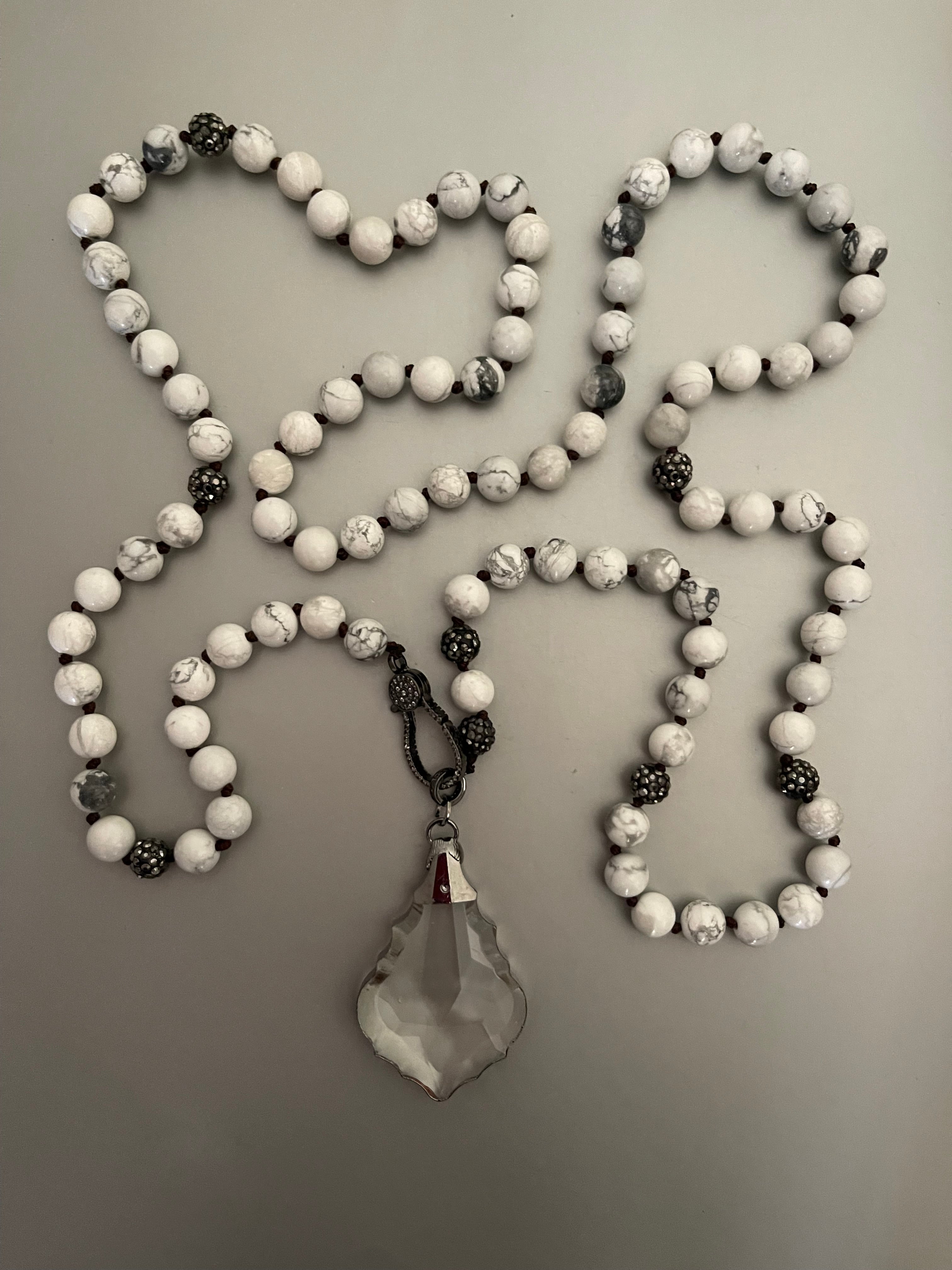 Collar Hippie Chic largo con elegante colgante de cristal facetado translusido, piedras naturales anudadas Howlita en tonos blancos con vetas grises, cristales y broche con delicados cristales.