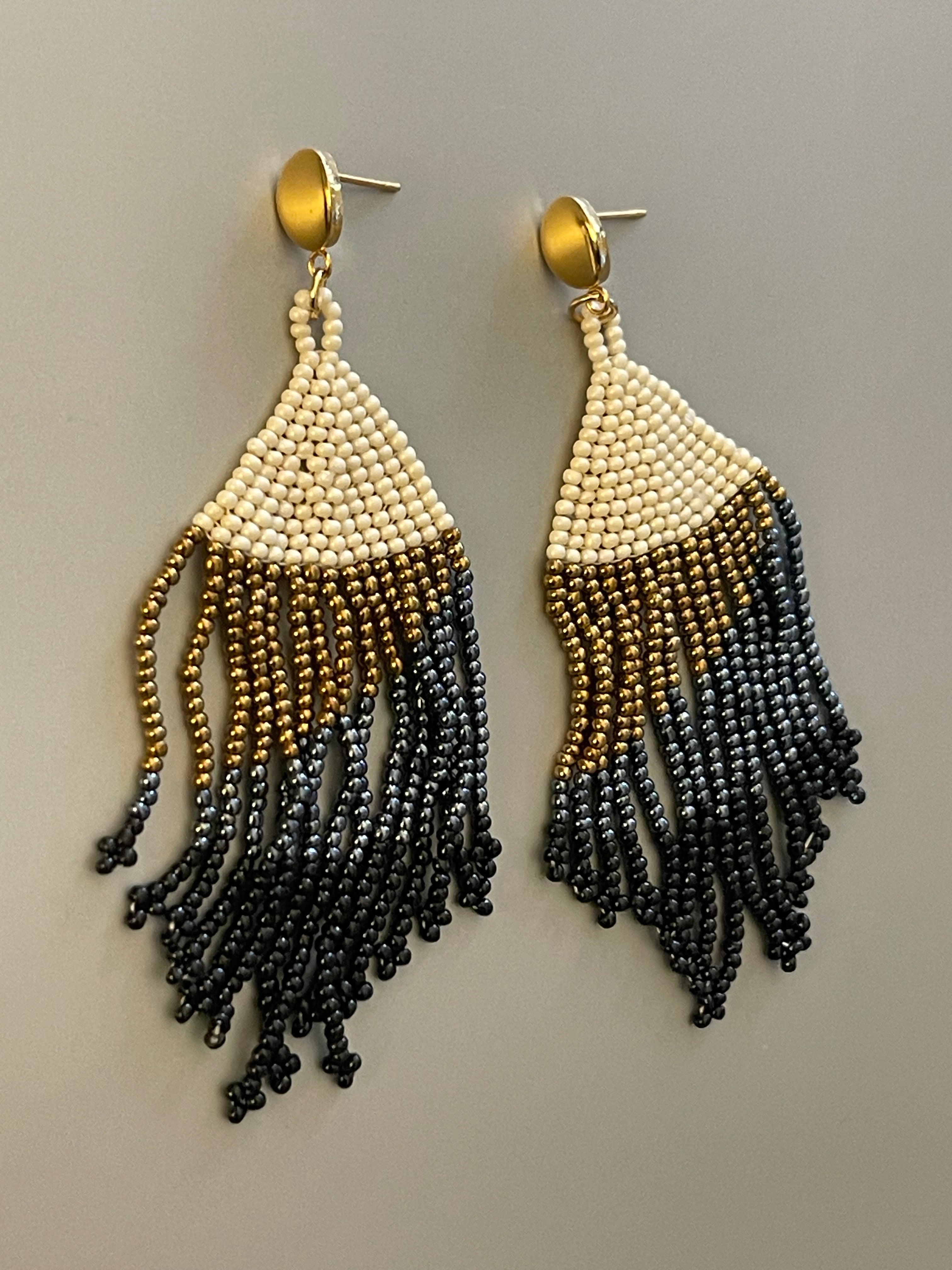 Aros Hippie Chic largos de elegantes mostacillas en tonos blanco invierno, dorados, grises, negros y base de acero inoxidable dorado.. Largo 9 cm.