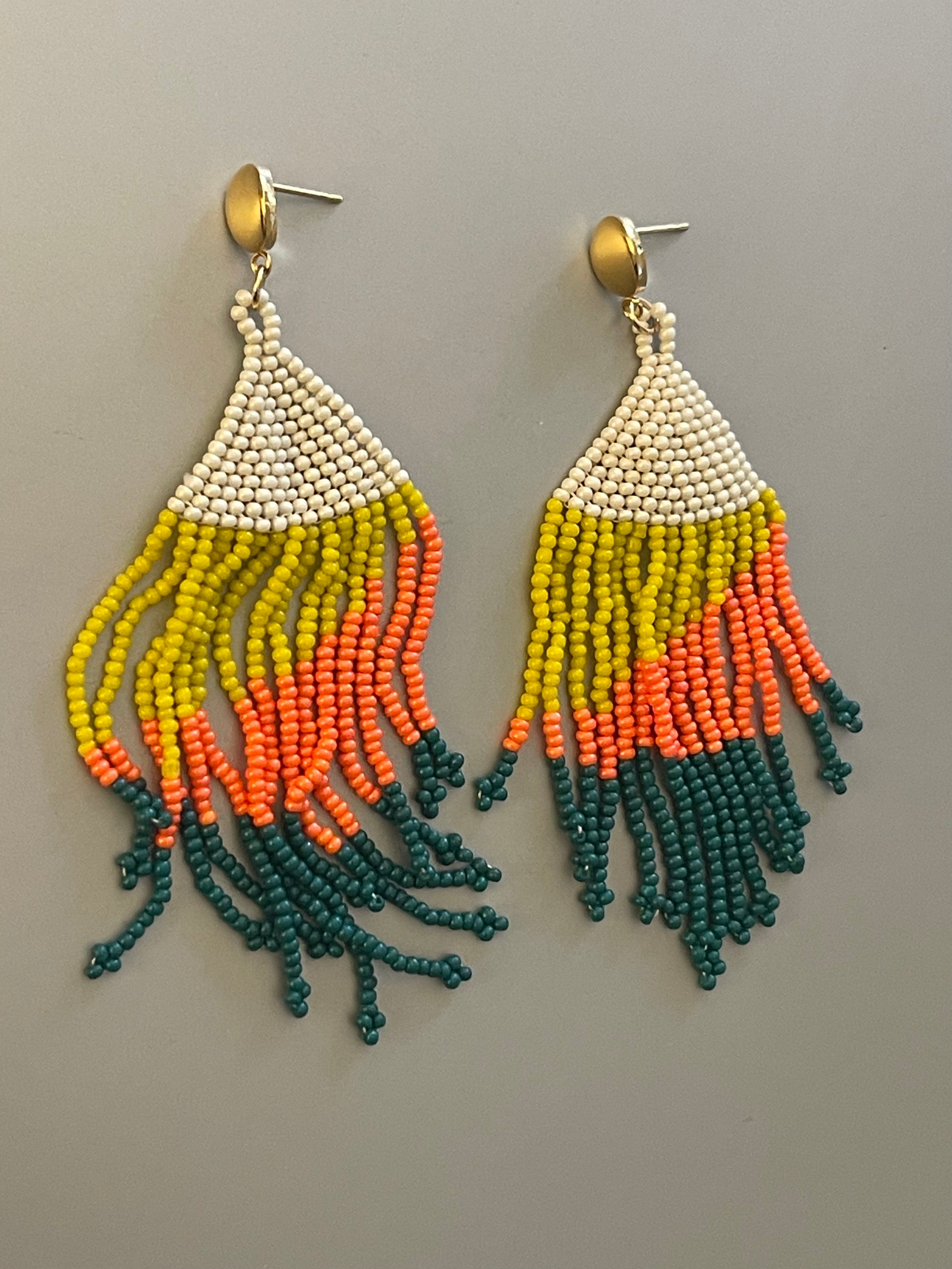Aros Hippie Chic largos con alegres mostacillas en tonos blanco invierno, amarillo, naranjo, verde y base de acero inoxidable dorado. Largo 9 cm.