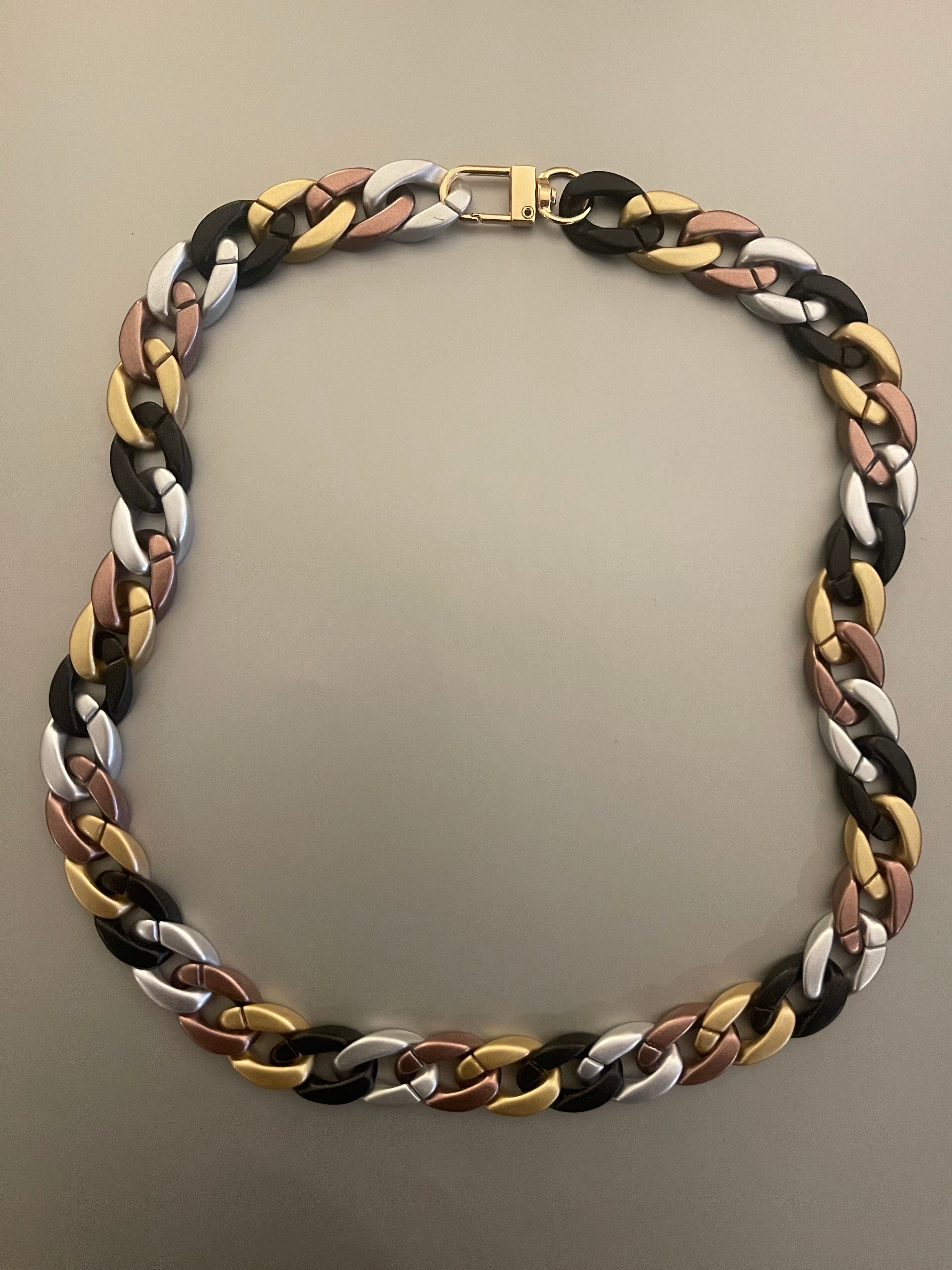 Collar Hippie Chic corto de acrilico en preciosa combinacion de negro, dorado, plateado y broche dorado.