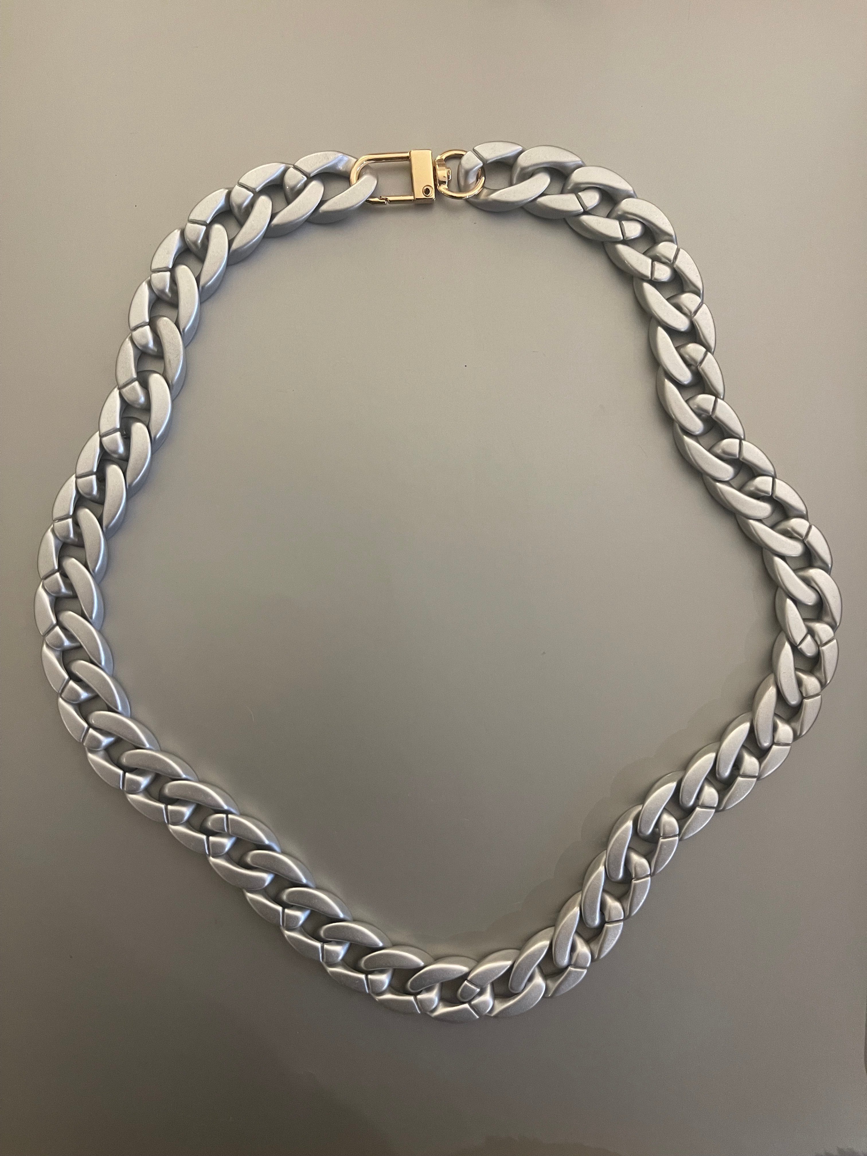 Collar Hippie Chic corto de acrilico en precioso tono plateado y broche dorado.