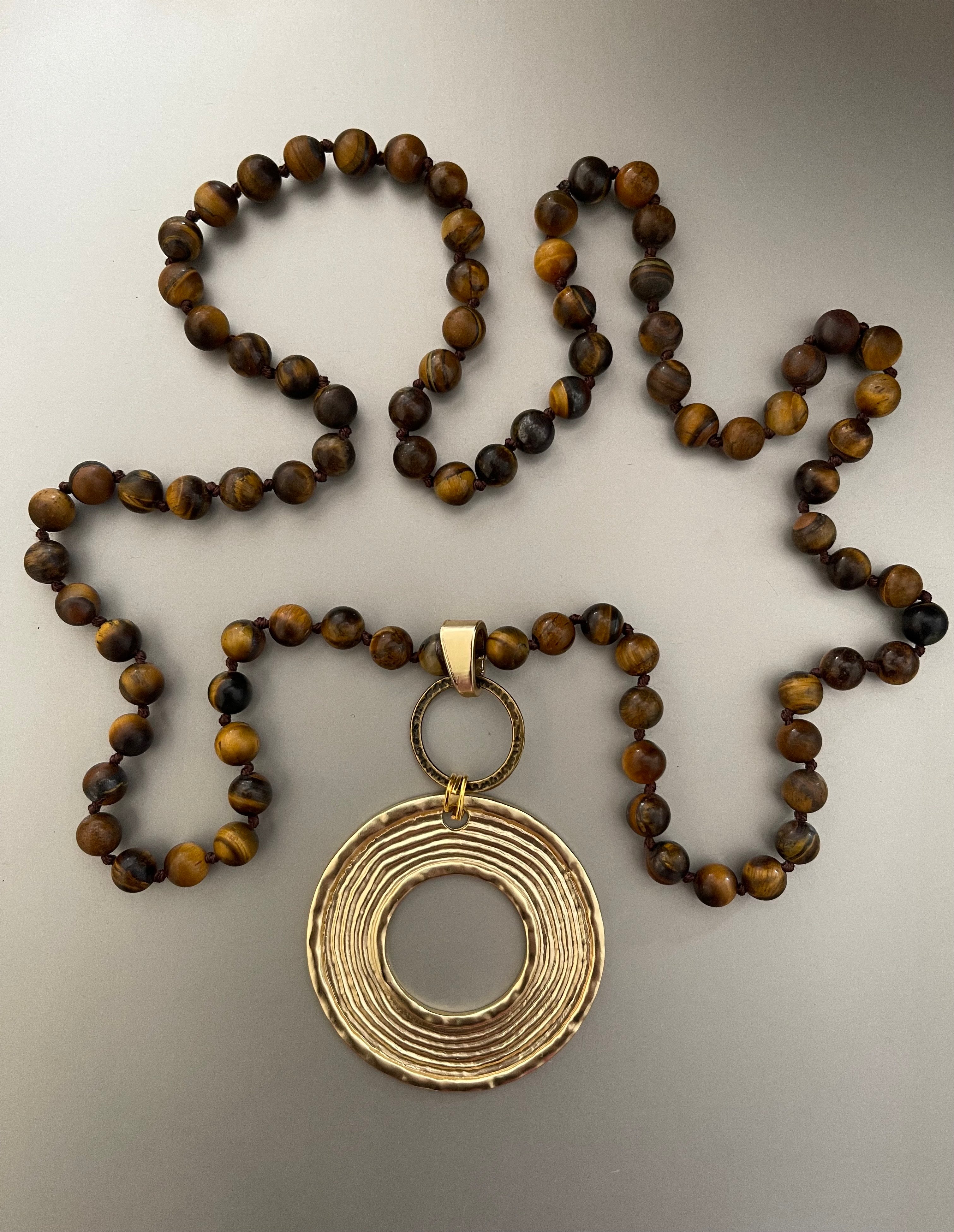 Collar Hippie Chic largo de piedras naturales en elegantes tonos marron con  fino colgante dorado.