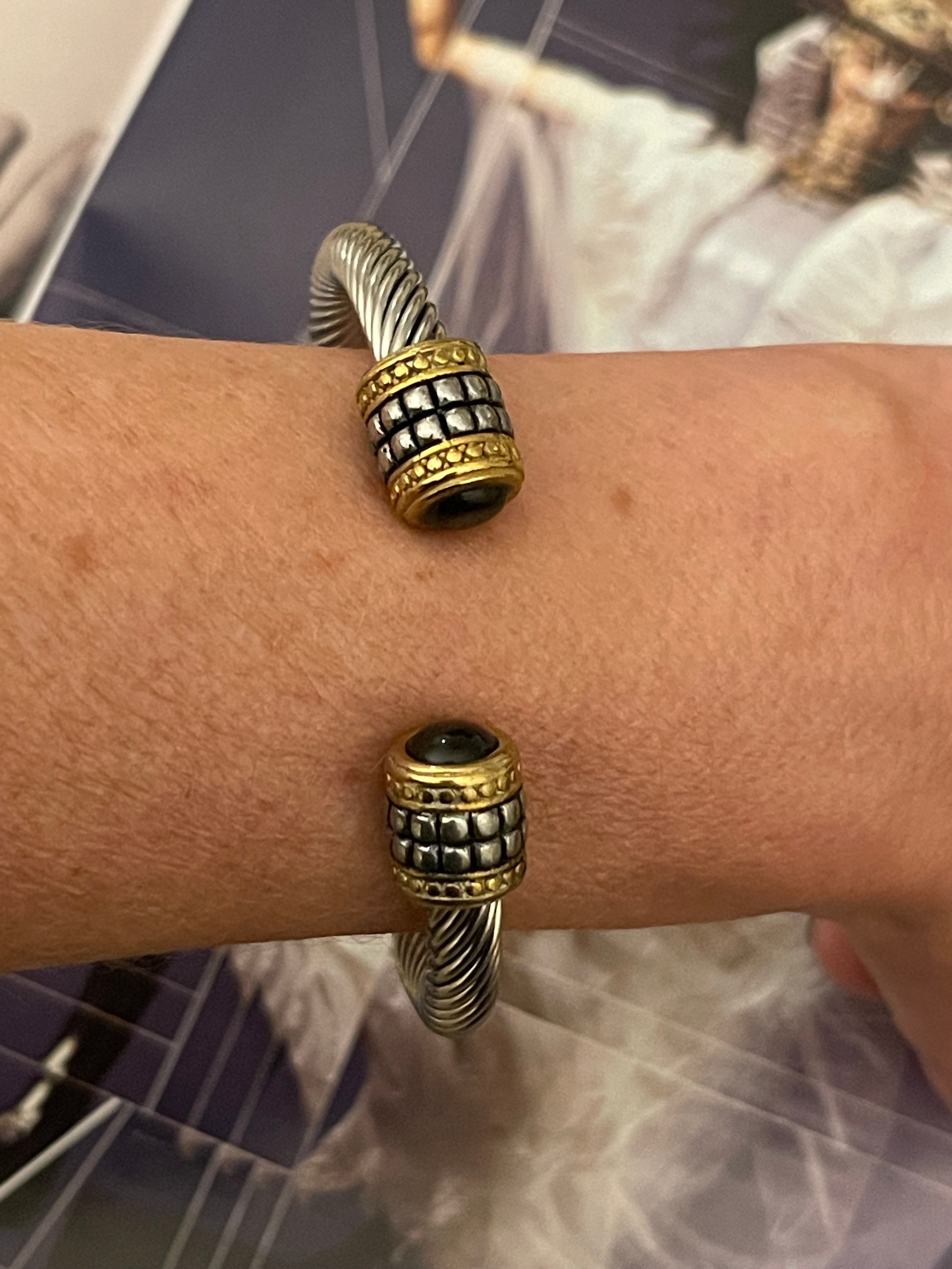Pulsera Hippie Chic de acero inoxidable plateado y preciosos detalles en las puntas en acero dorado y cristal negro.