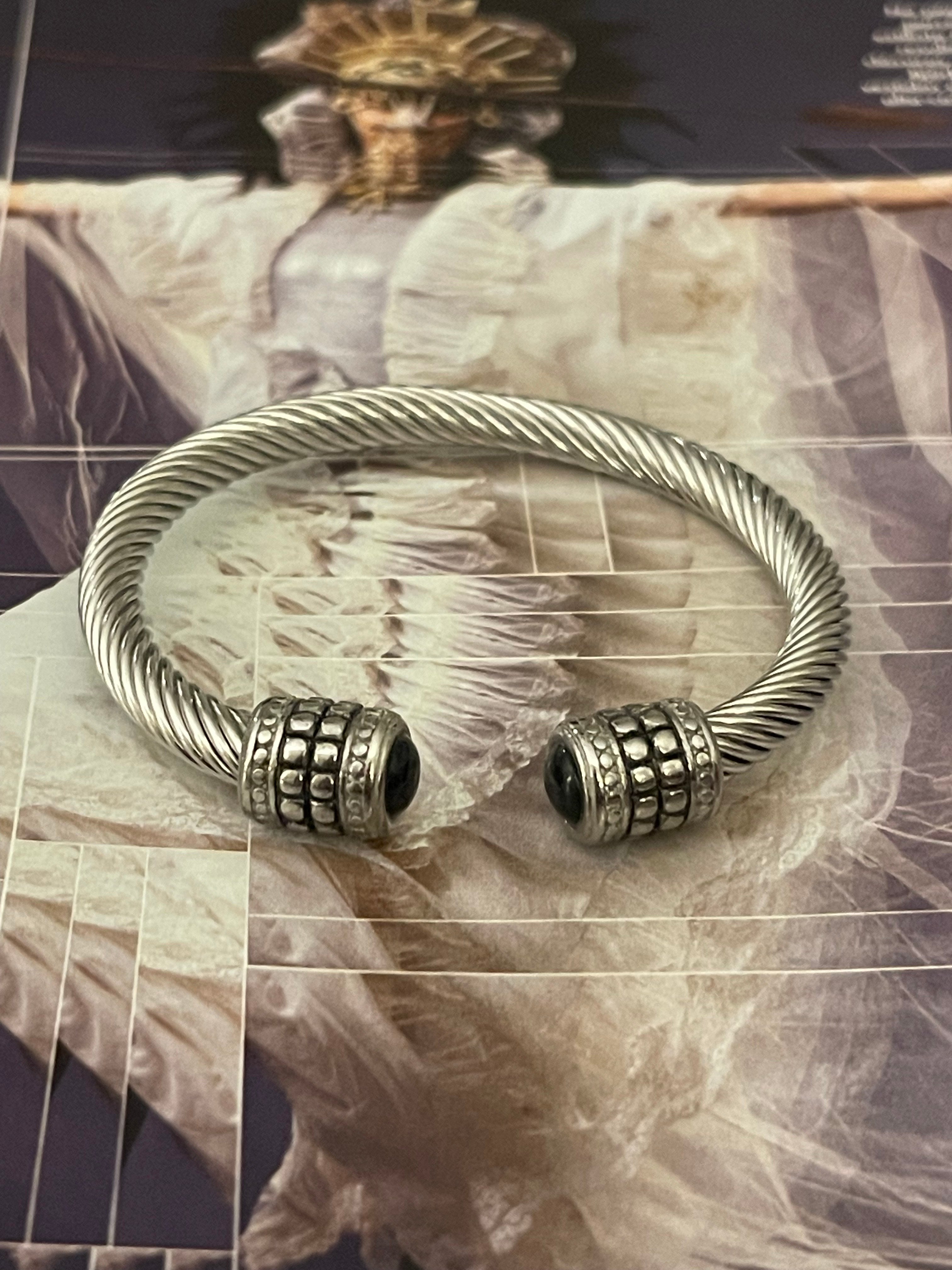 Pulsera Hippie Chic de acero inoxidable plateado con preciosos detalles en las puntas y cristal negro.