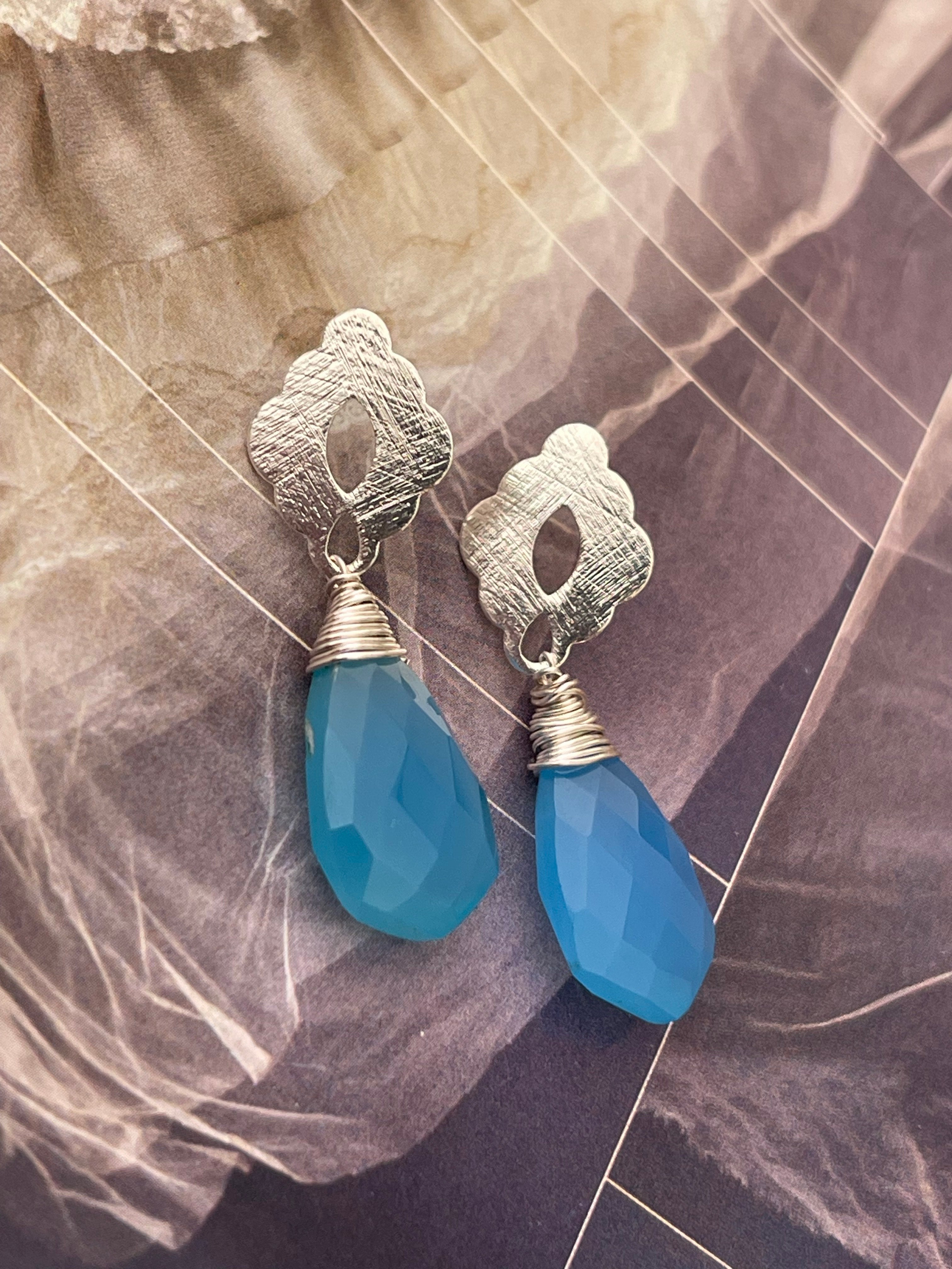 Aros Hippie Chic bañados en plata y delicada piedra Calcedonia celeste embarrilada con hilo de plata. Largo 4 cm.m.