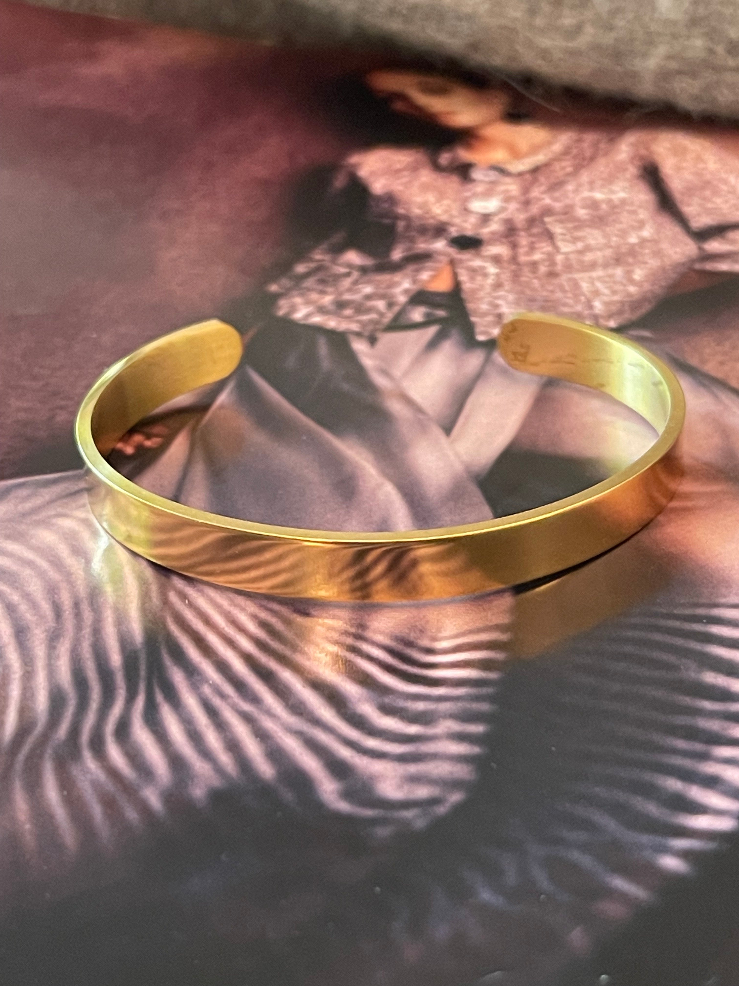 Pulsera Hippie Chic en acero inoxidable dorado en elegante diseño tipo esclava de tamaño mediano.