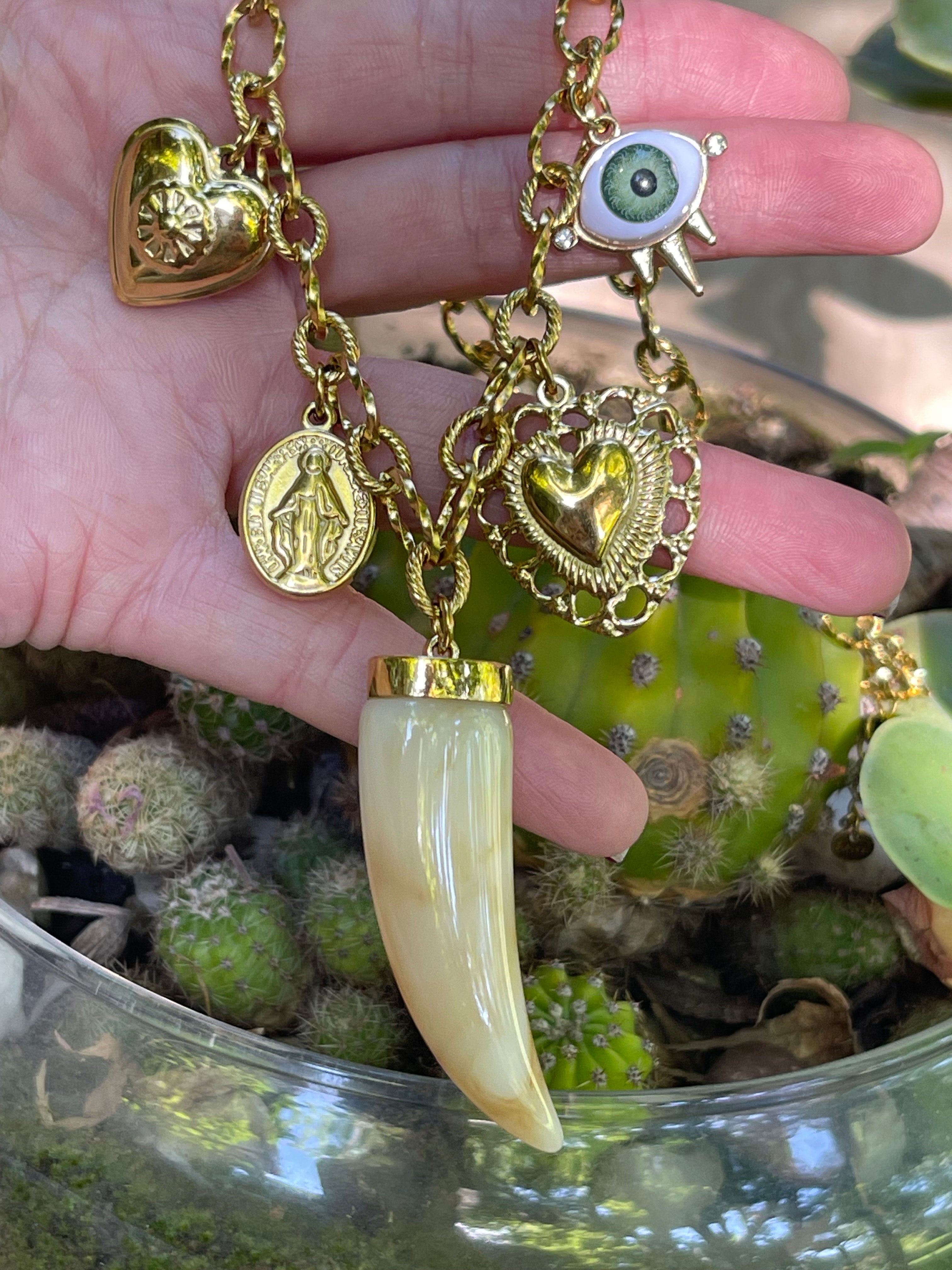 Collar Hippie Chic corto con cadena de acero inoxidable dorado y preciosos colgantes con un colmillo principal en acrilico en tonos beige.