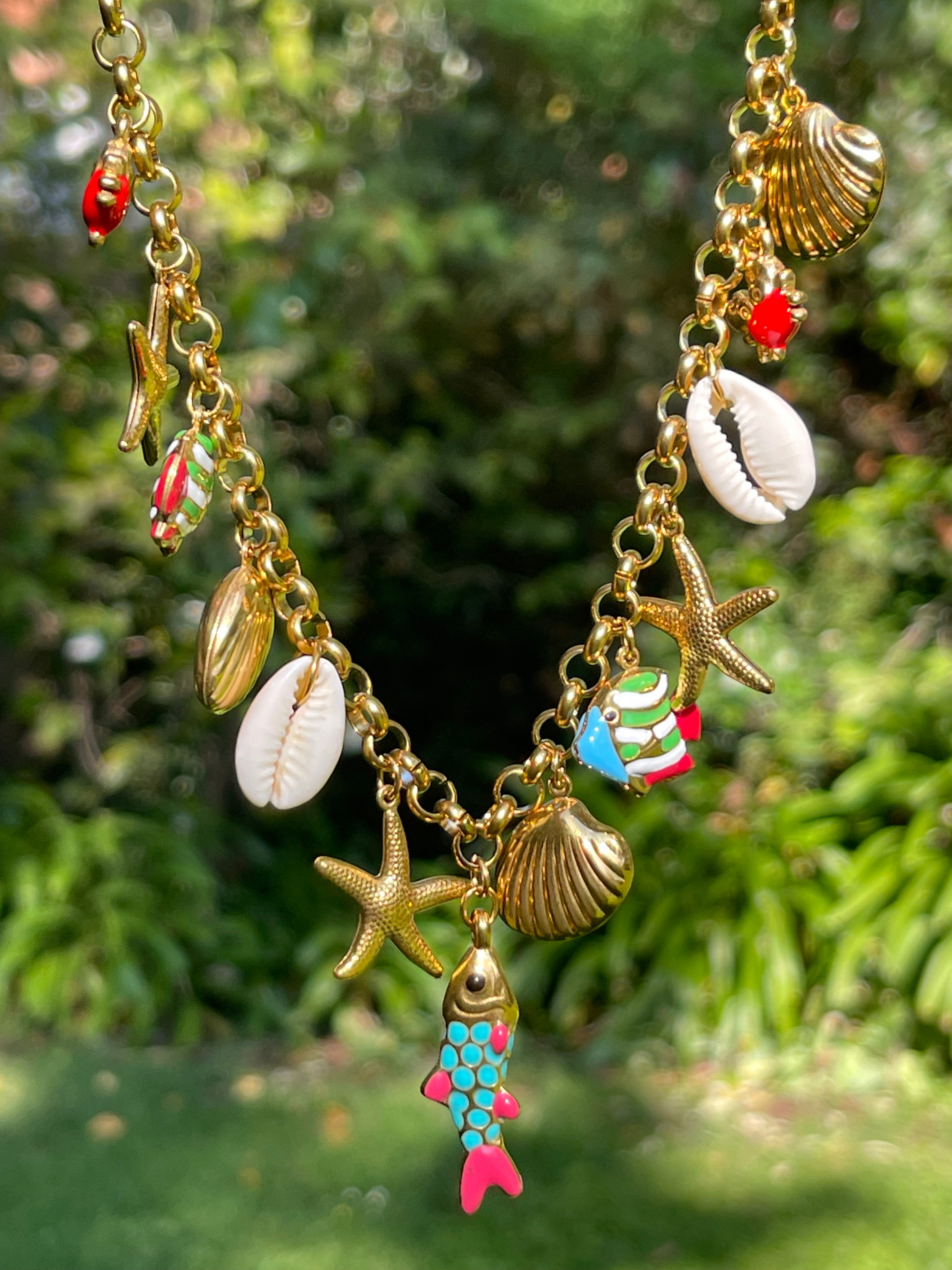 Collar Hippie Chic corto de cadena de acero inoxidable dorado con preciosos mini colgantes con motivos maritimos en acero y acrilico y concha natural.