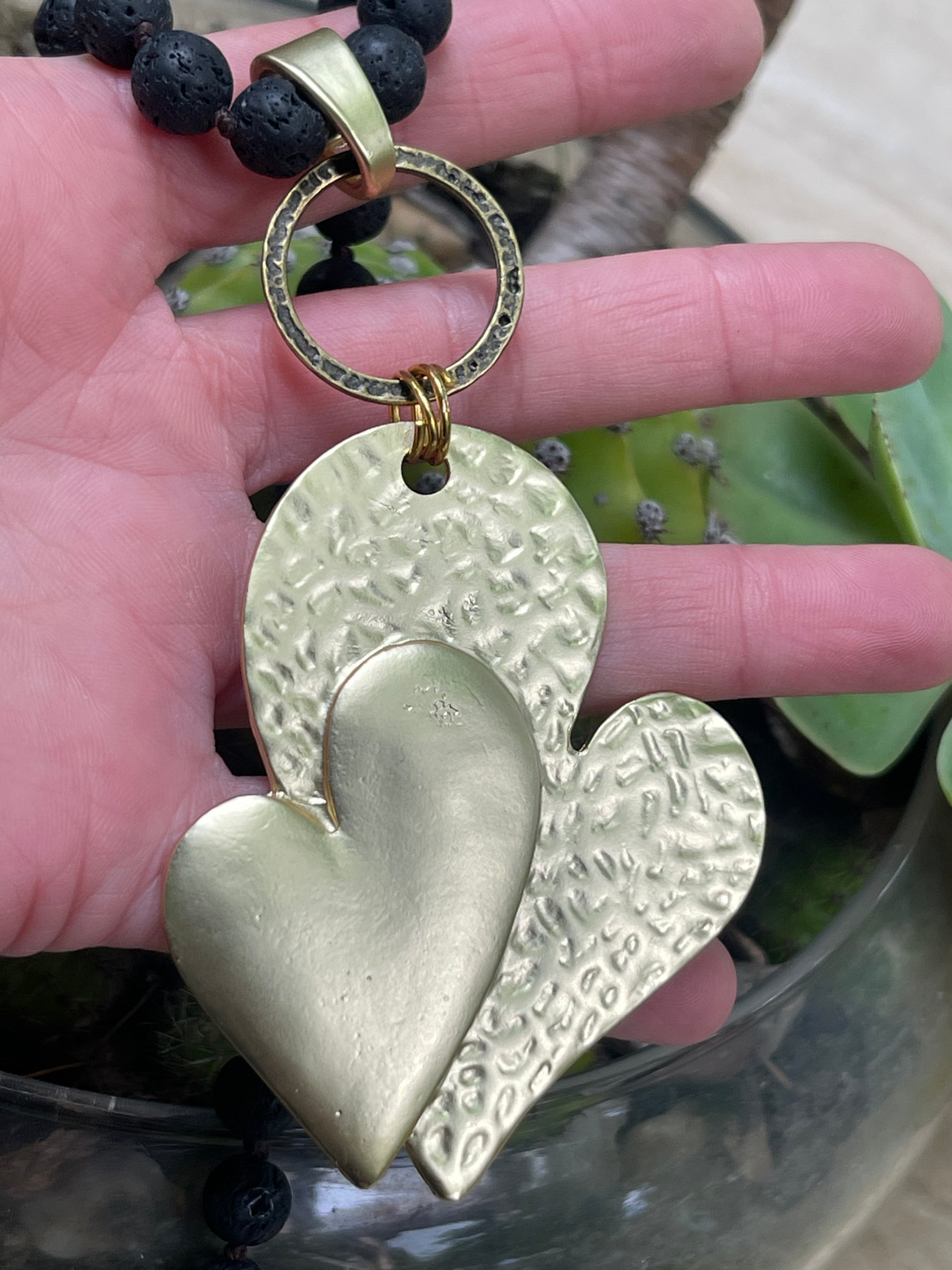 Collar Hippie Chic largo de piedras volcanicas naturales negras anudadas y precioso colgante de corazon dorado opaco.