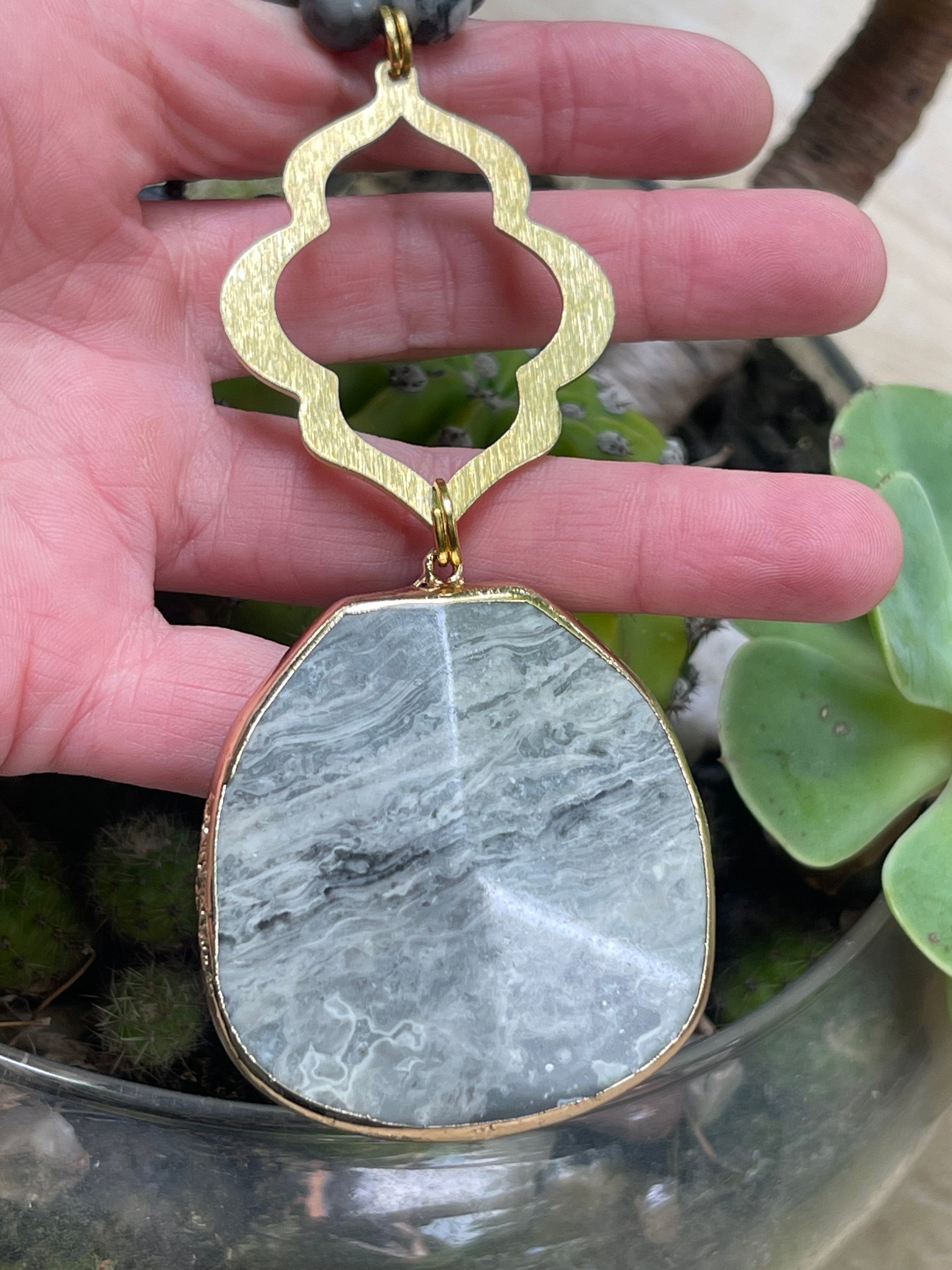 Collar Hippie Chic largo de elegantes piedras en tonos grises anudadas y conector dorado.