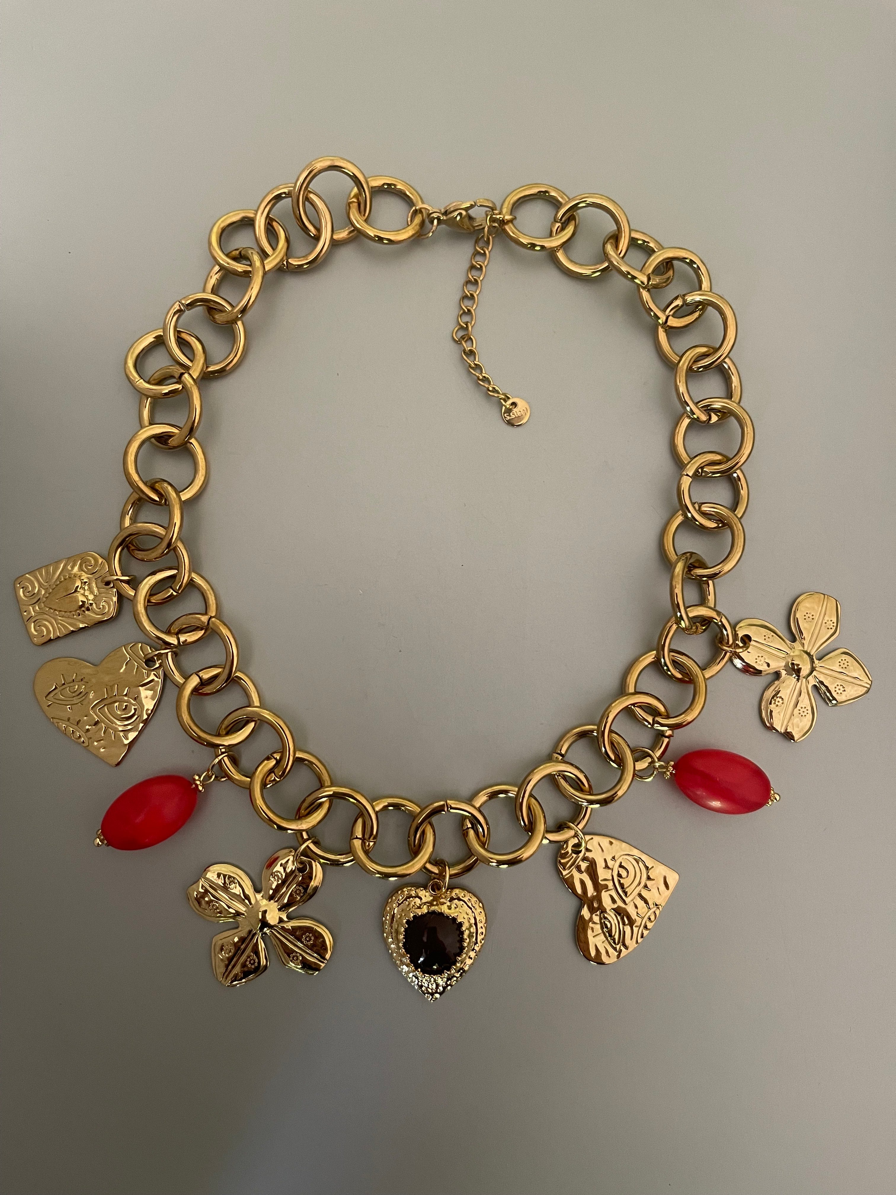 Collar Hippie Chic corto con espectacular cadena y colgantes en acero inoxidable dorado y acrilico en tonos rojos.