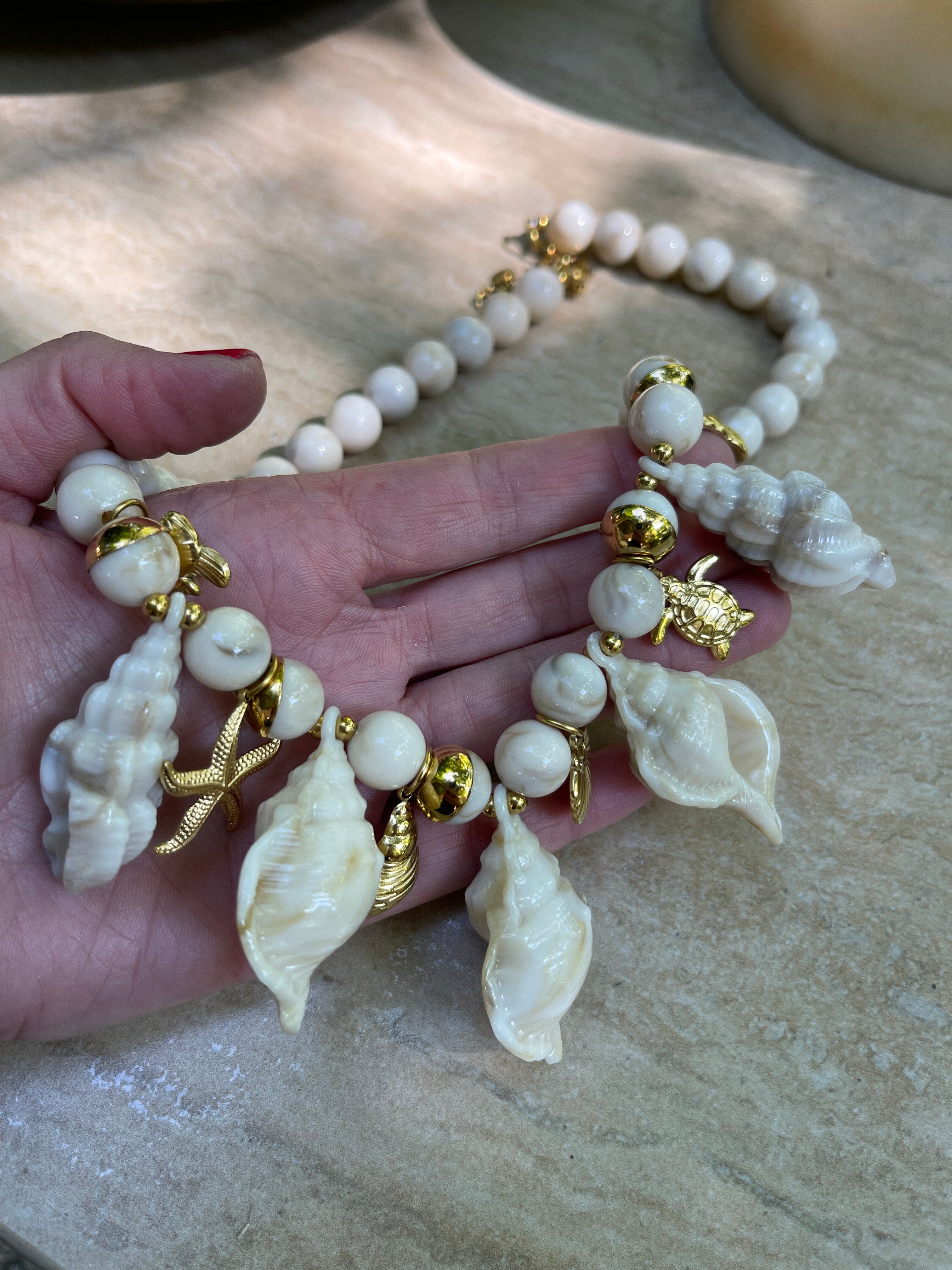 Collar Hippie Chic corto con preciosos motivos maritimos en acrilico beige y colgantes y cadena en acero inoxidable dorado.