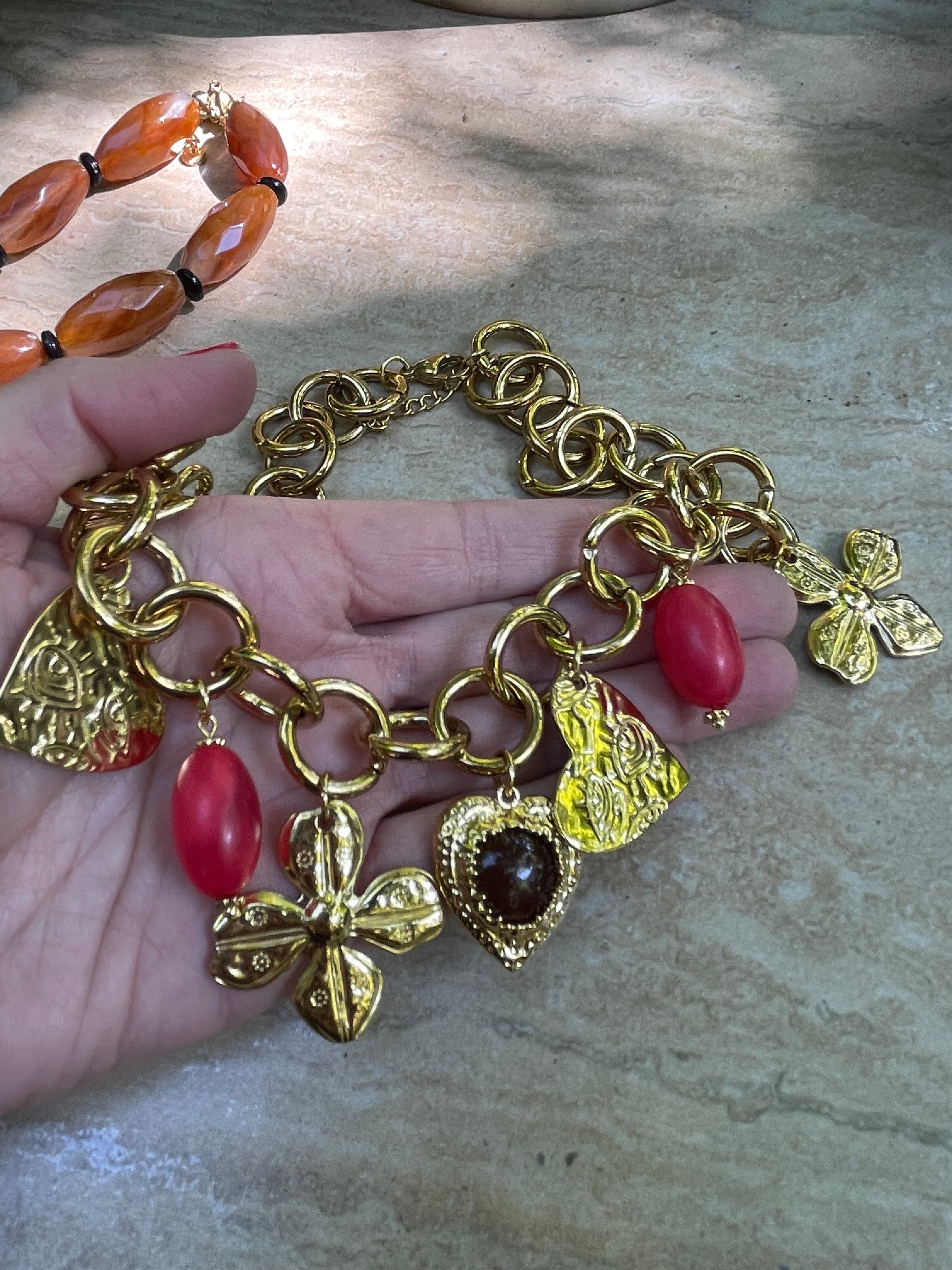 Collar Hippie Chic corto con espectacular cadena y colgantes en acero inoxidable dorado y acrilico en tonos rojos.
