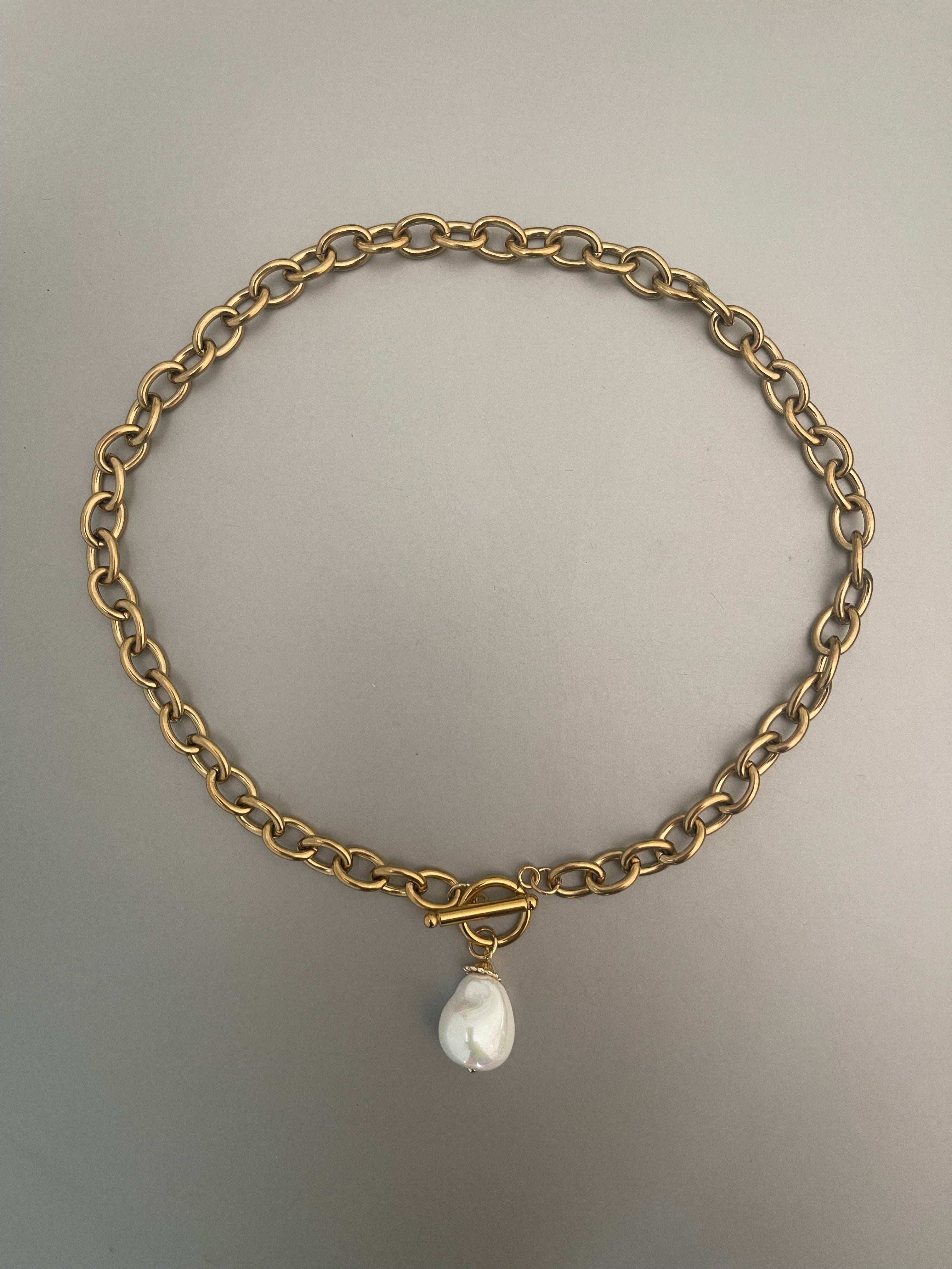 Collar Hippie Chic corto de acero inoxidable dorado con cierre OT y elegante perla barroca blanca de fantasia fina con un precioso esmaltado.