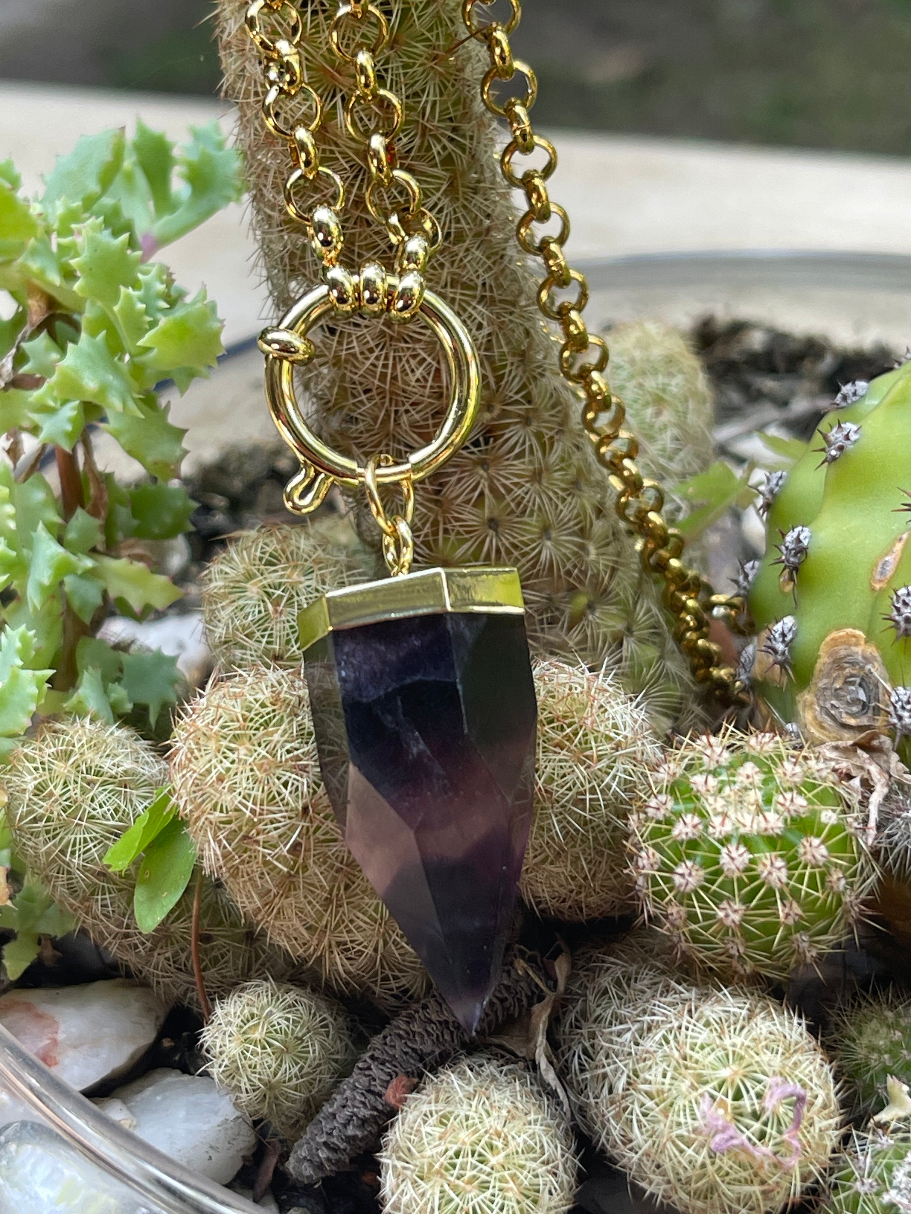 Collar Hippie Chic largo de cadena de acero inoxidable dorado y preciosa piedra natural en tonalidades lilas. Lleva un cierre tipo timón y una estrellita.