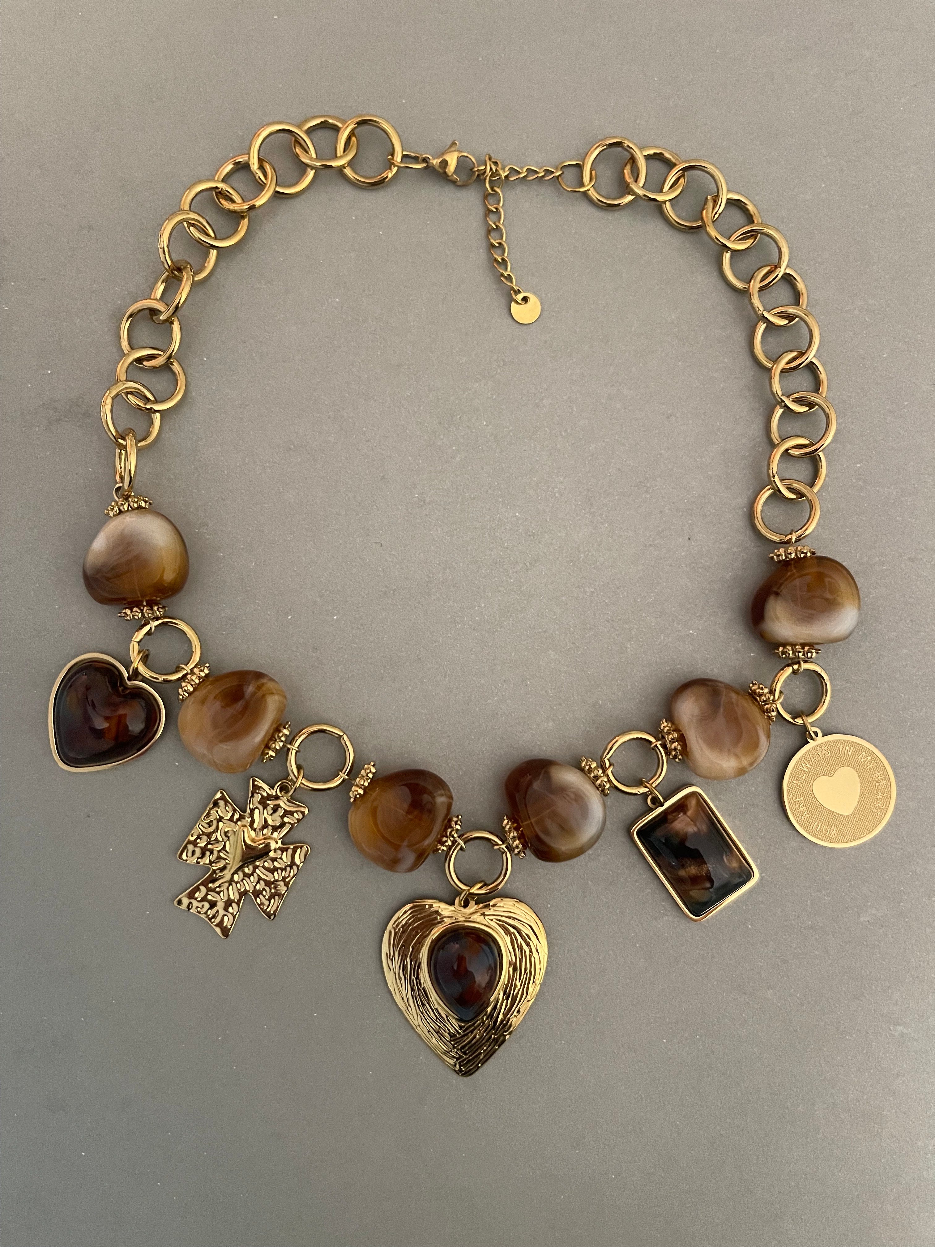 Collar Hippie Chic corto con preciosa cadena de acero inoxidable dorada y colgantes en aclico en tonos marron y acero dorado.