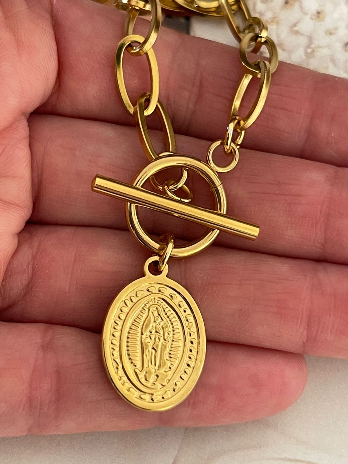 Pulsera de acero inoxidable dorado con precioso cierre OT y colgante de Virgen.