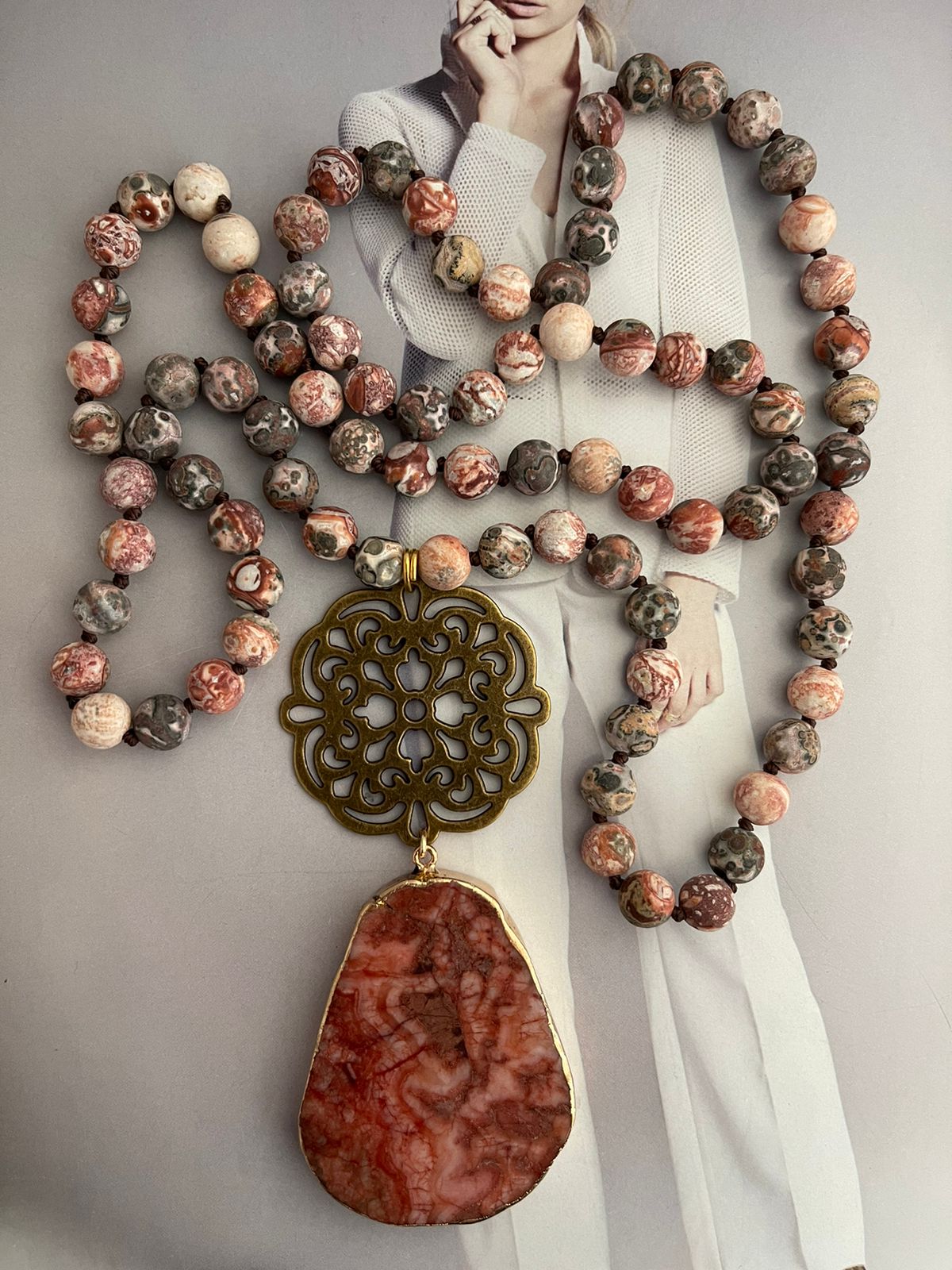 Collar Hippie Chic largo de piedras naturales anudadas en tonos rojos, rosas, blancos y marron, con colgante en los tonos y mandala y precioso mandala envejecido.