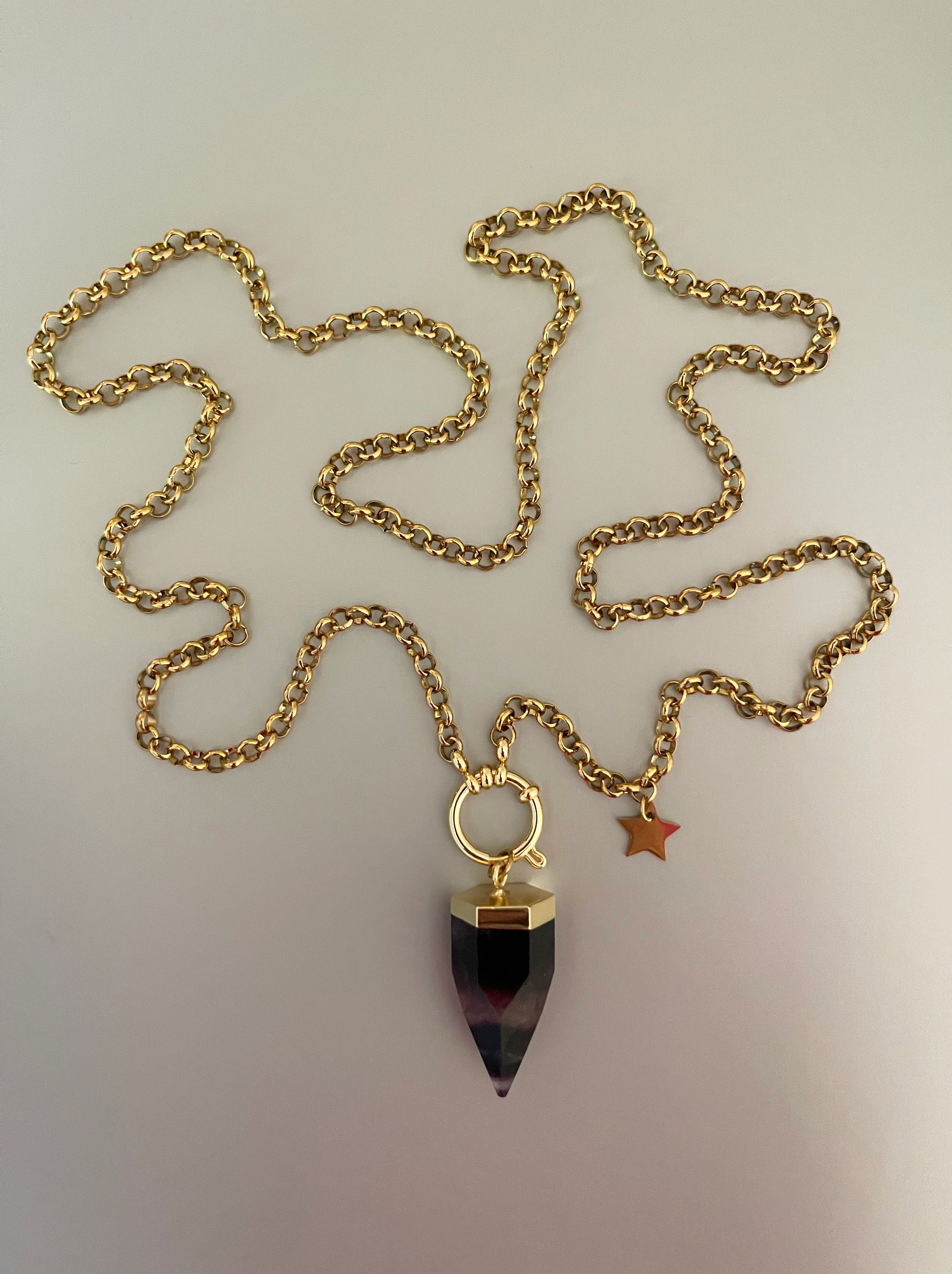 Collar Hippie Chic largo de cadena de acero inoxidable dorado y preciosa piedra natural en tonalidades lilas. Lleva un cierre tipo timón y una estrellita.