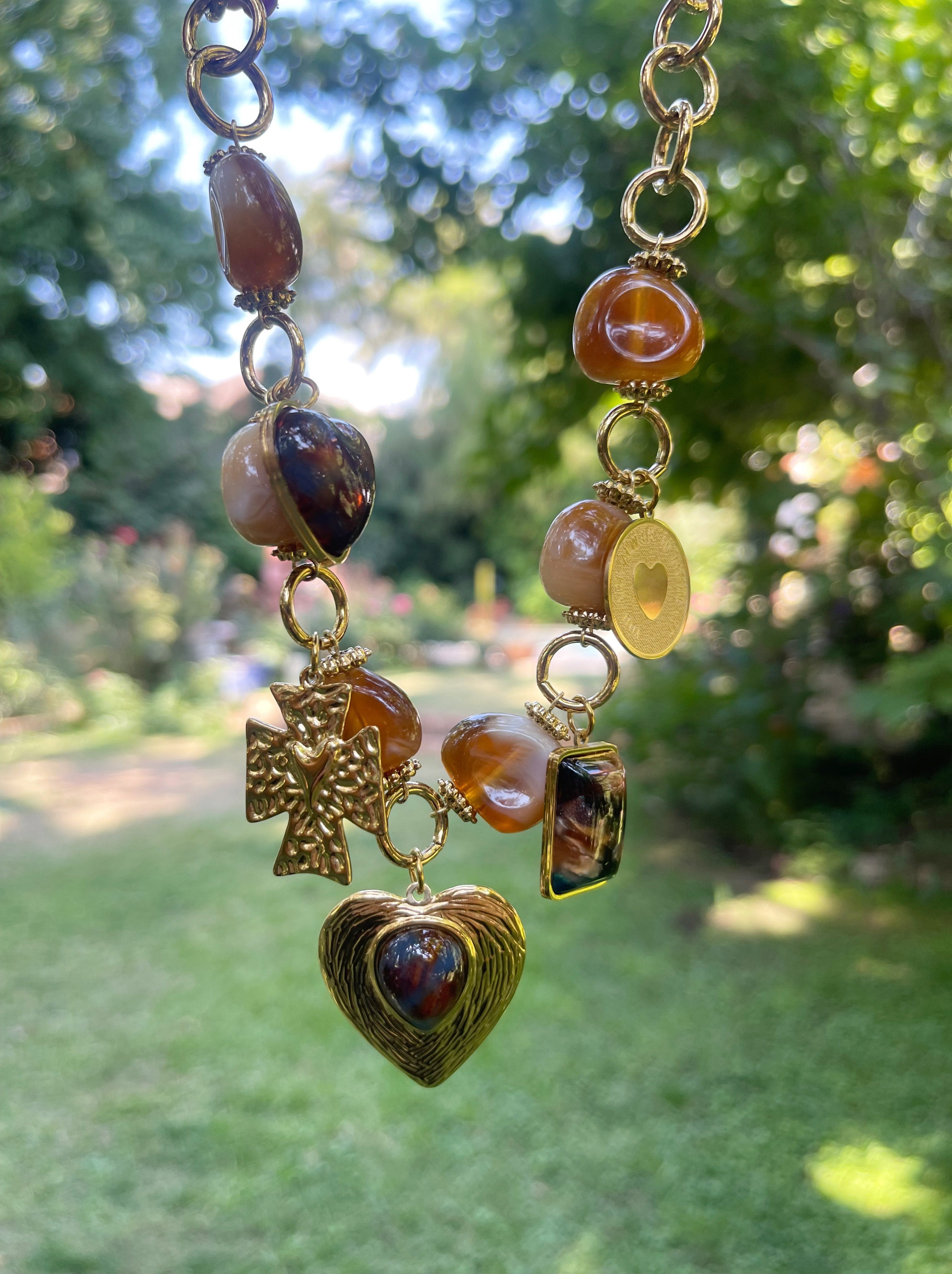 Collar Hippie Chic corto con preciosa cadena de acero inoxidable dorada y colgantes en aclico en tonos marron y acero dorado.