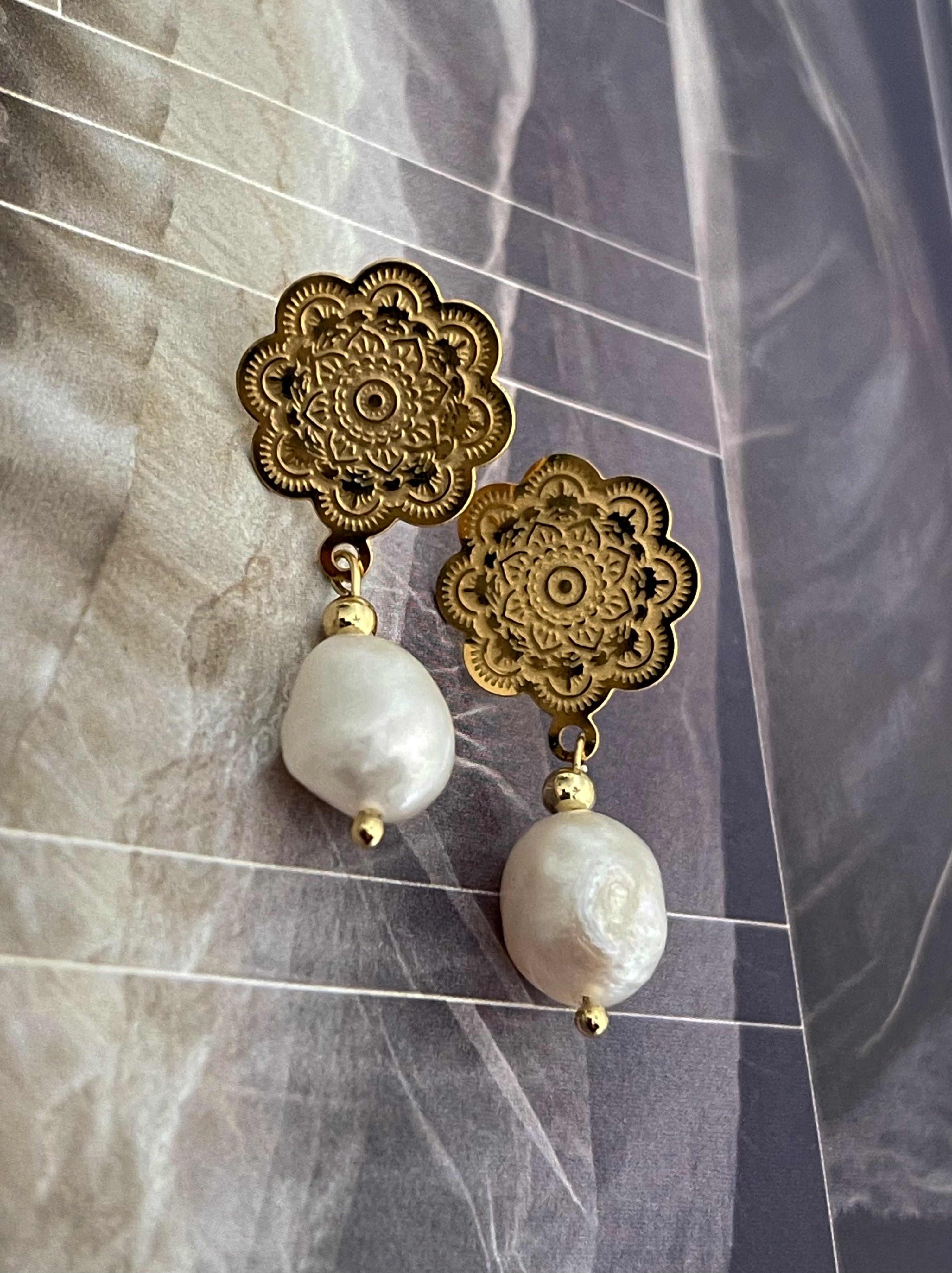 Aros Hippie Chic con base de acero inoxidable dorado con precioso diseño de flor y perla natiral blanca. Largo 3.5 cm.