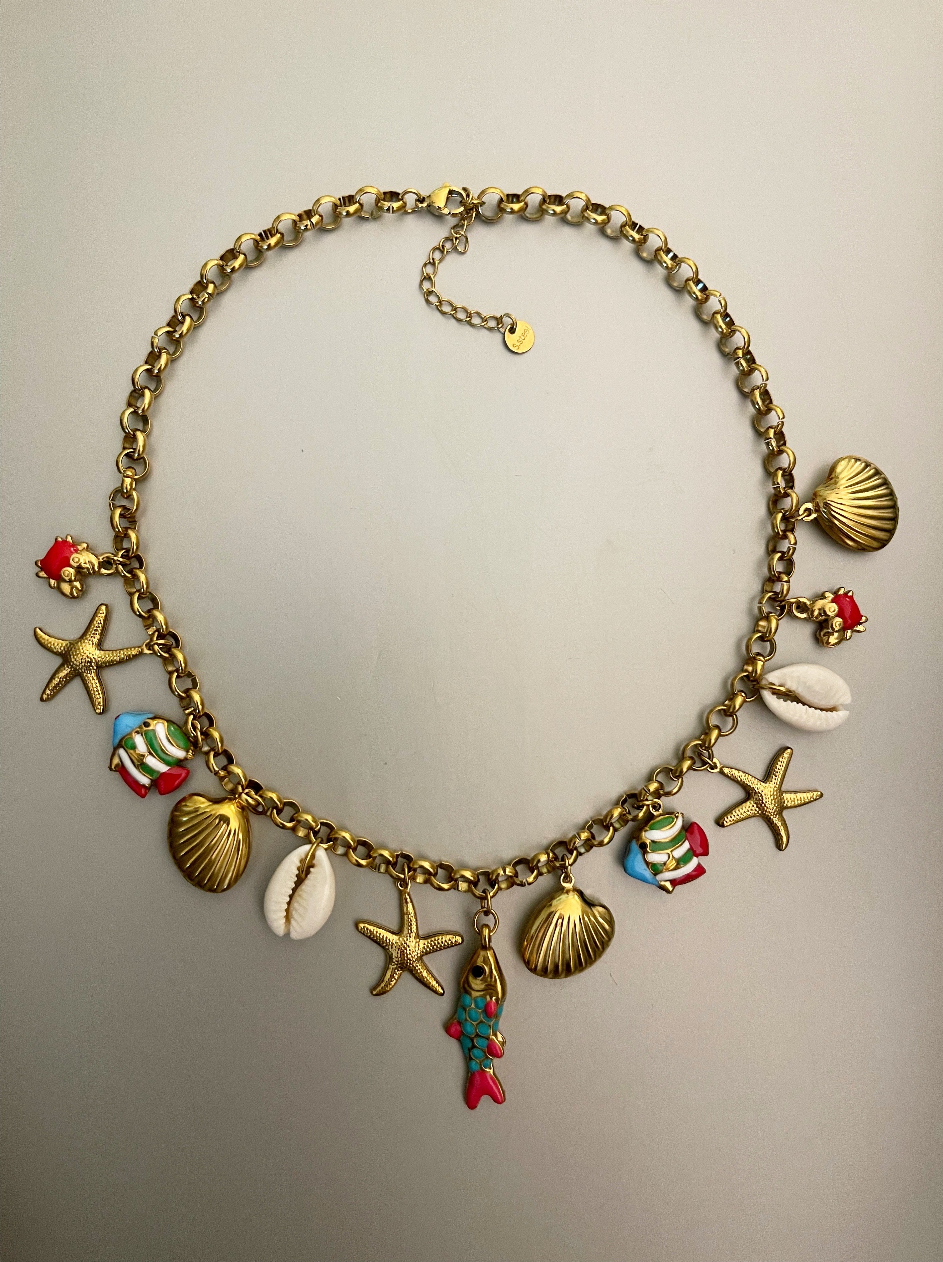 Collar Hippie Chic corto de cadena de acero inoxidable dorado con preciosos mini colgantes con motivos maritimos en acero y acrilico y concha natural.