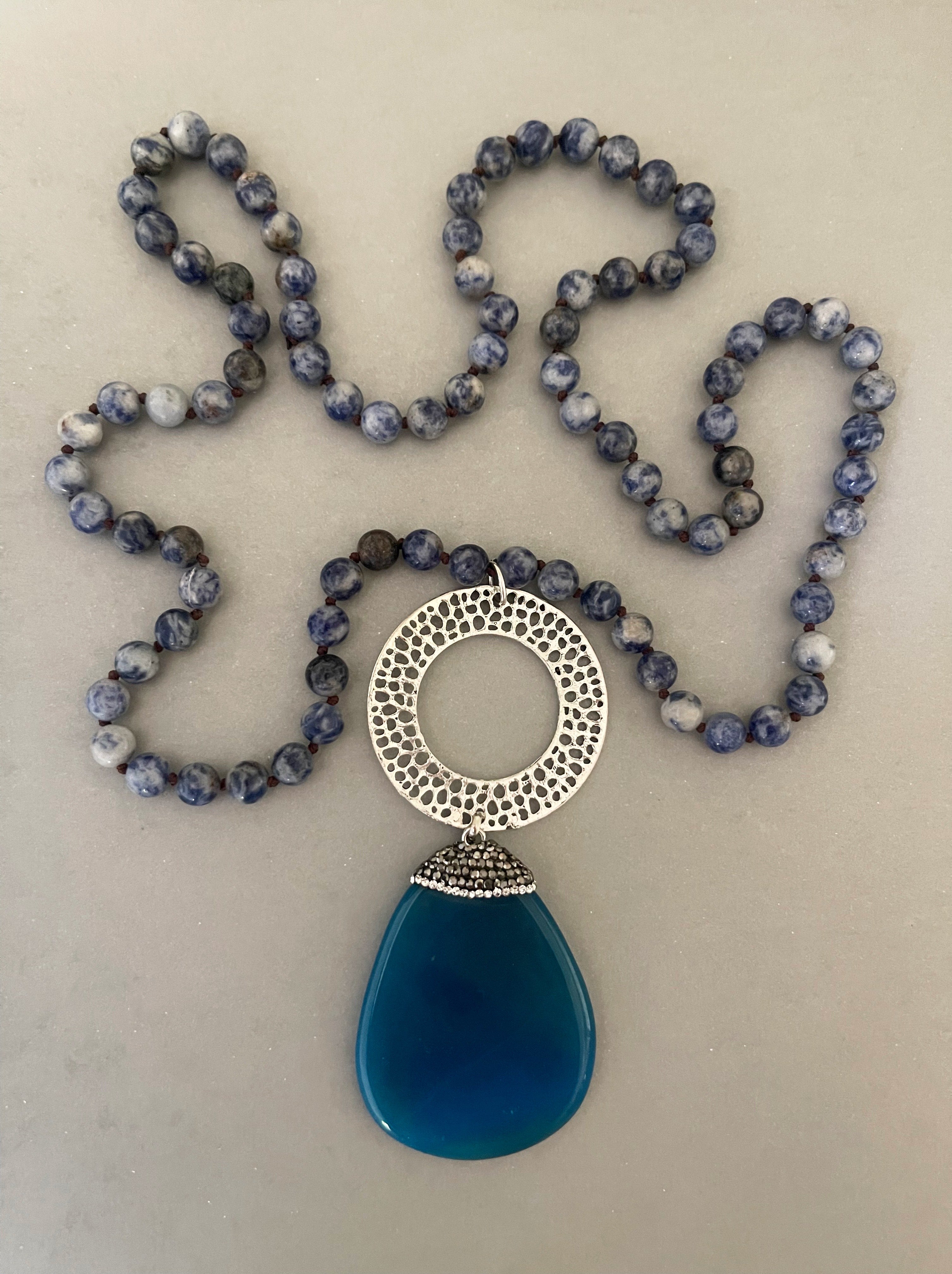 Collar Hippie Chic largo de piedras naturales anudadas en tonos azules con precioso colgante con detalles de cristales y base plateada.
