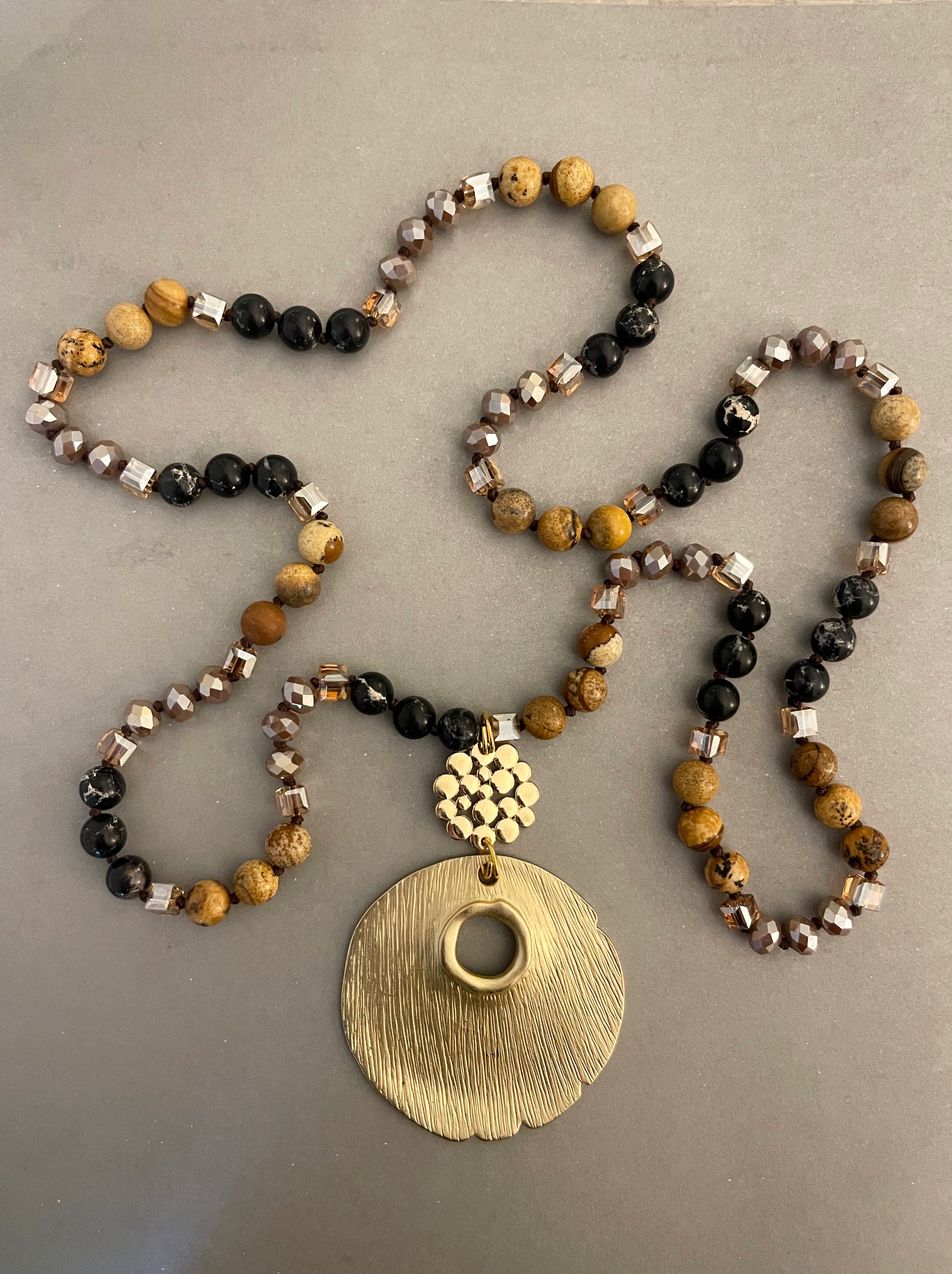 Collar Hippie Chic largo de piedras naturales y cristales anudados en tonos beige y negro con maravilloso colgante dorado.