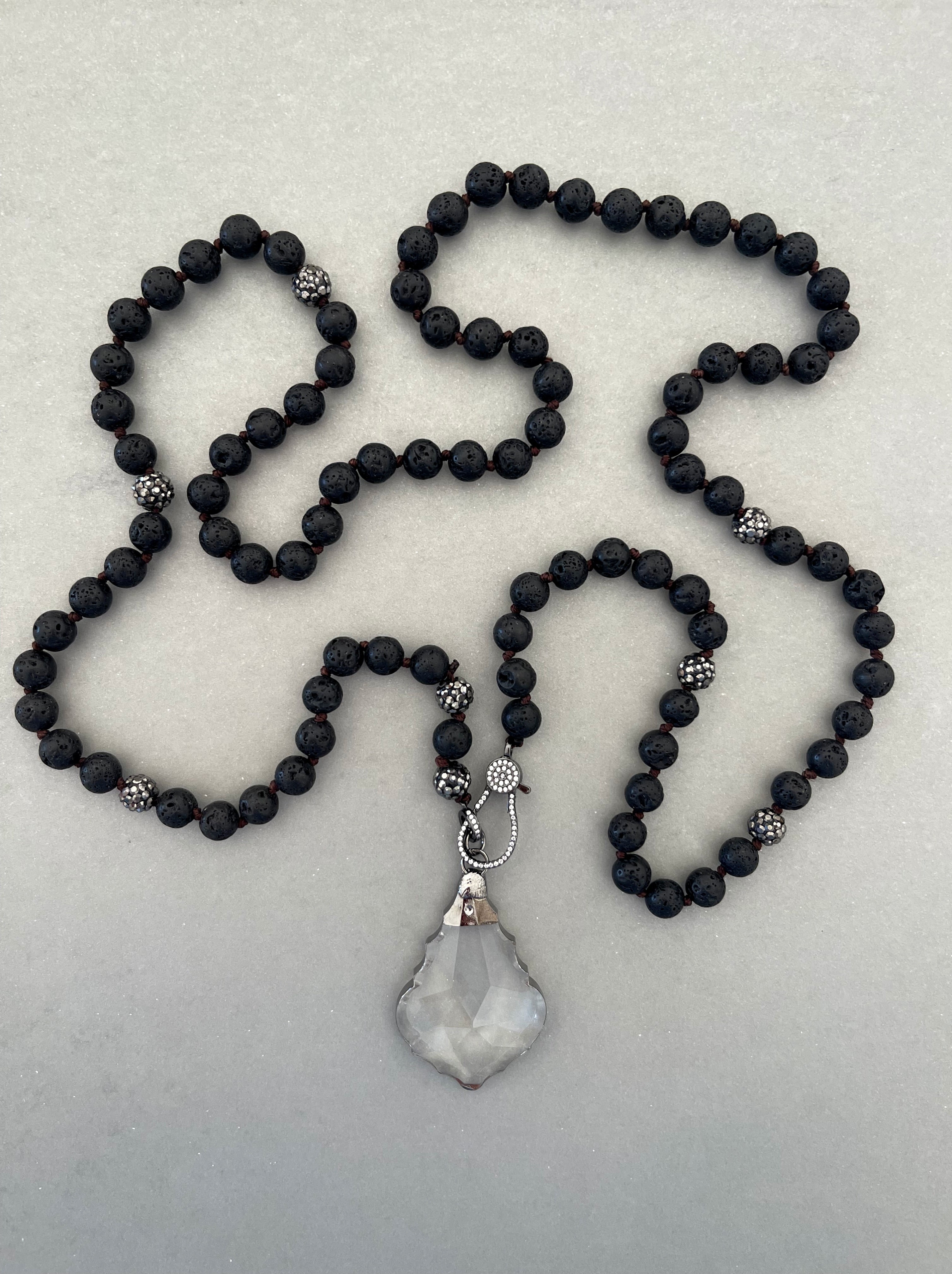 Collar Hippie Chic largo de piedras volcanicas y cristales negros anudados con precioso colgante de cristal facetado translusido.