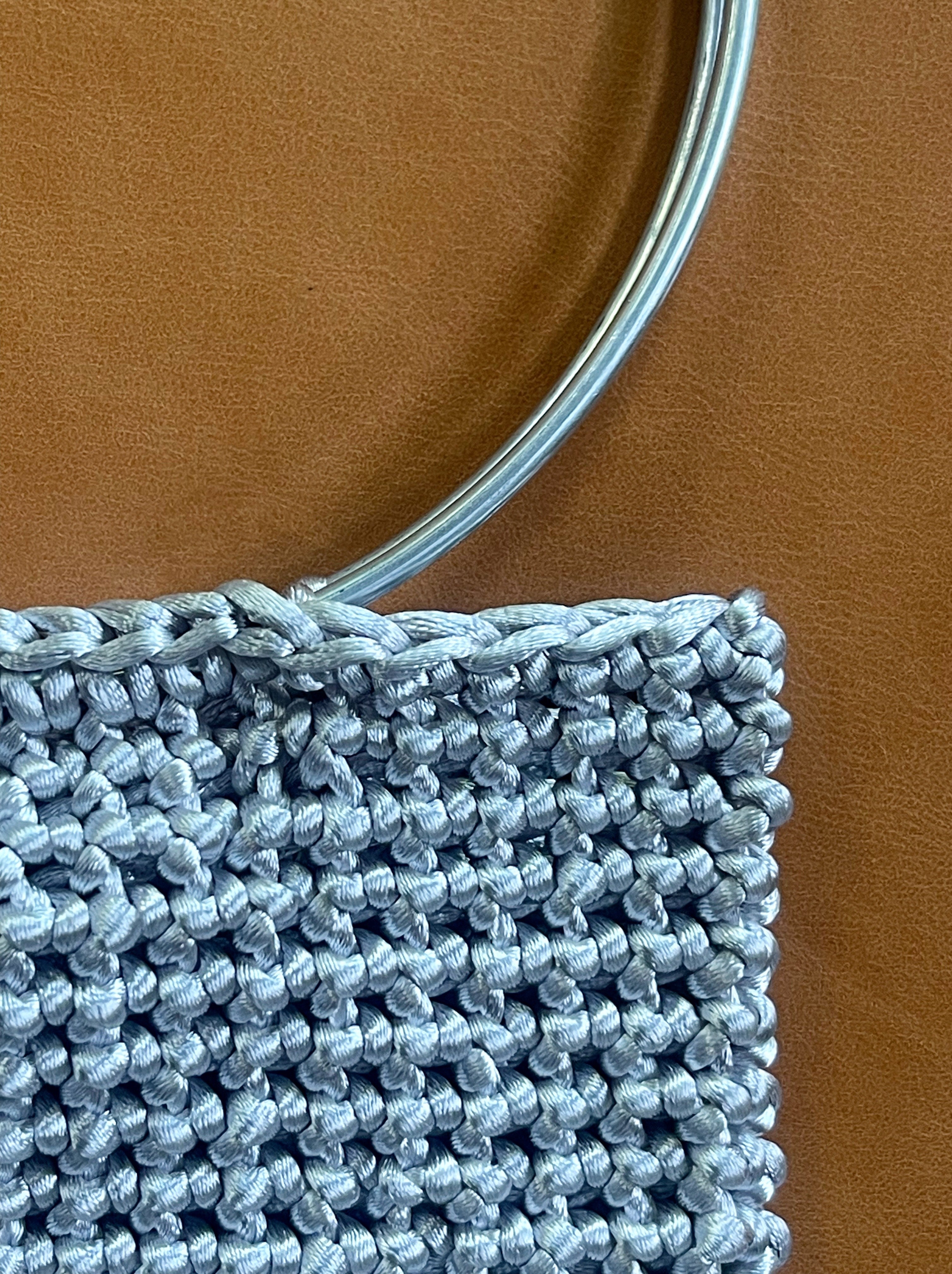 Cartera Hippie Chic en moderno color plateado, tejida a crochet con mango plateado.