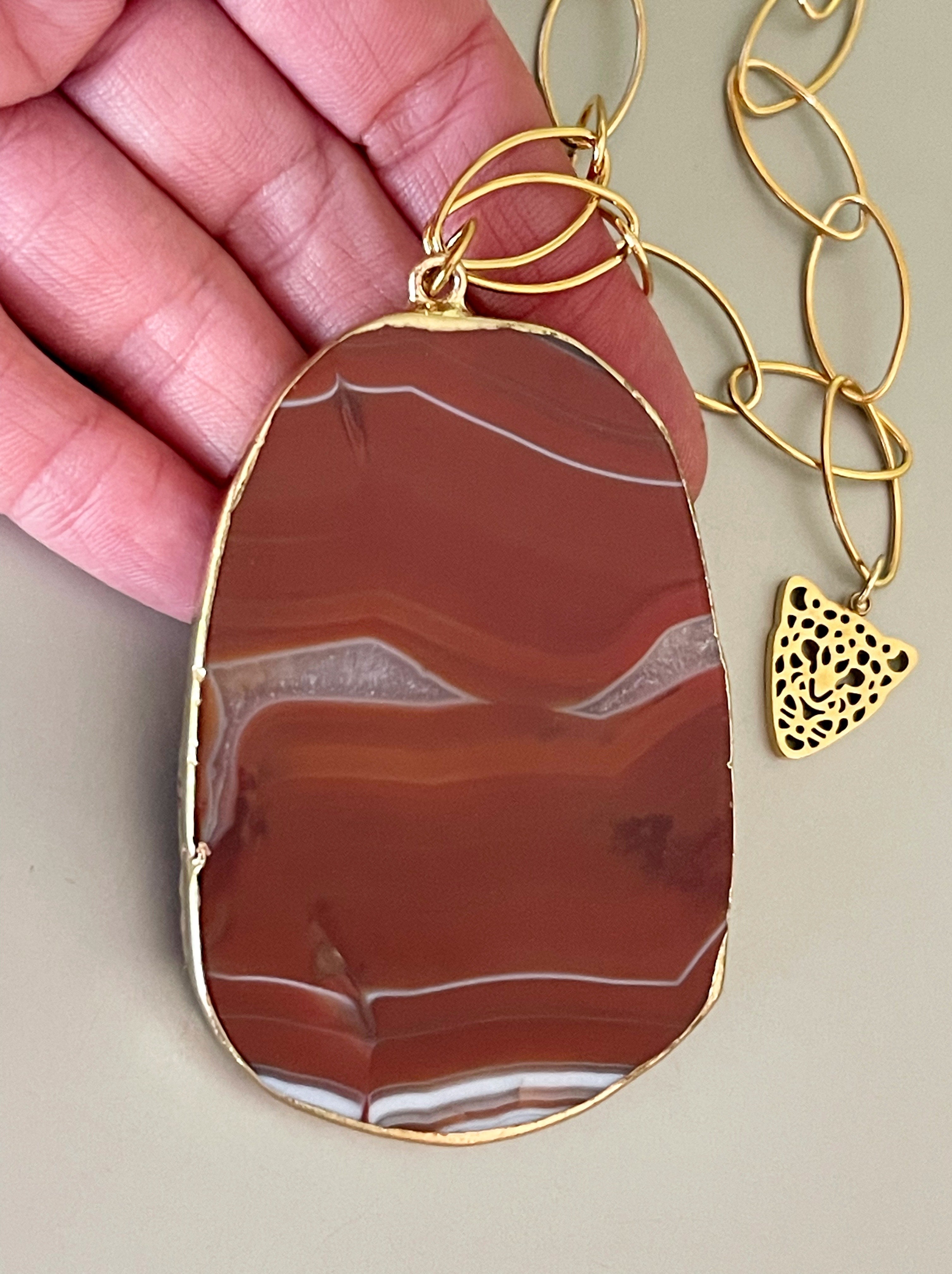 a y cadena de acero inoxidable dorado. La cadena lleva un mini colgante de cabeza de tigre y el cierre lleva un punto de luz.