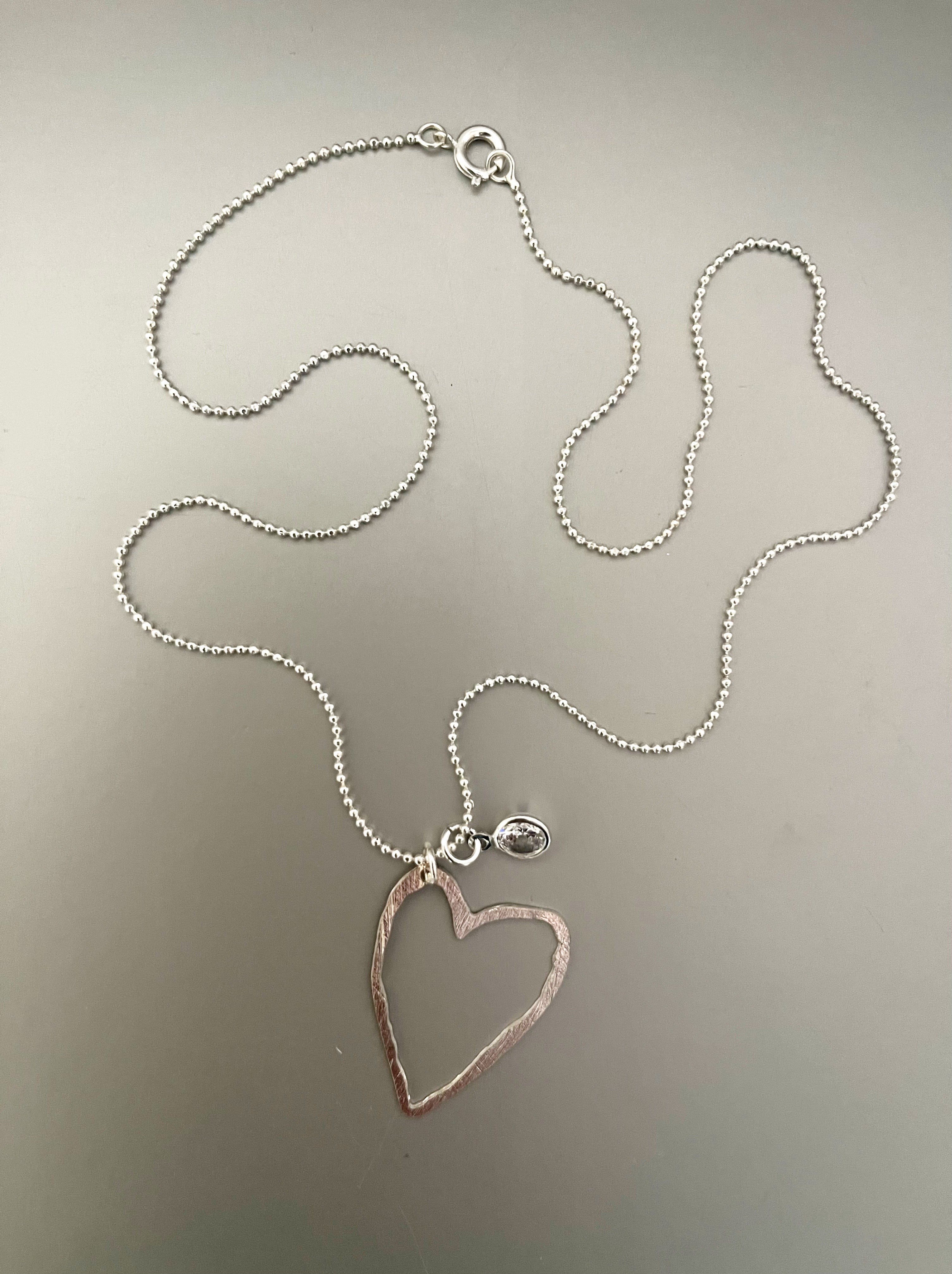Collar Hippie Chic corto bañado en plata con delicado corazon y punto de luz.