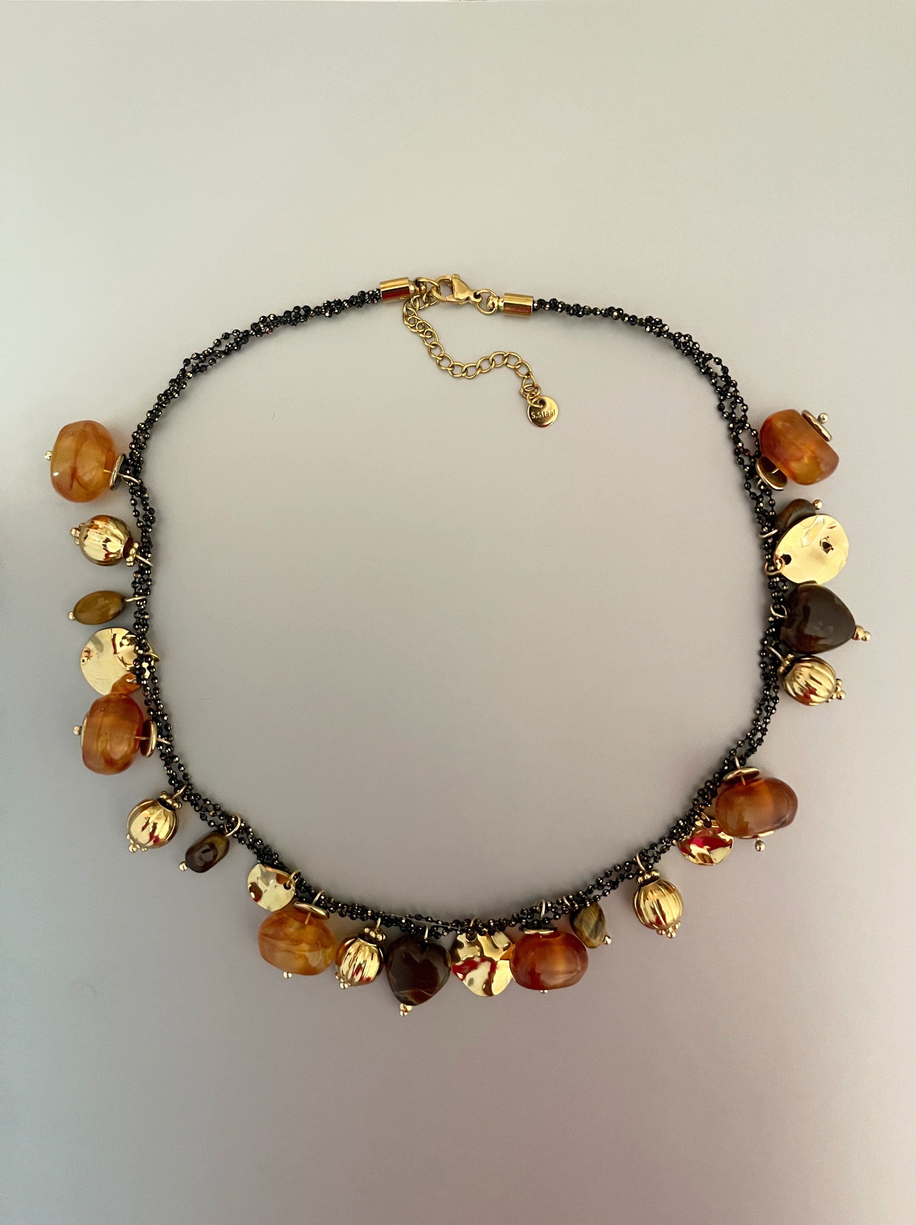 Collar Hippie Chic corto de acero inoxidable dorado, preciosos colgantes en acrilico color caramelo y mostacillas en el contorno.