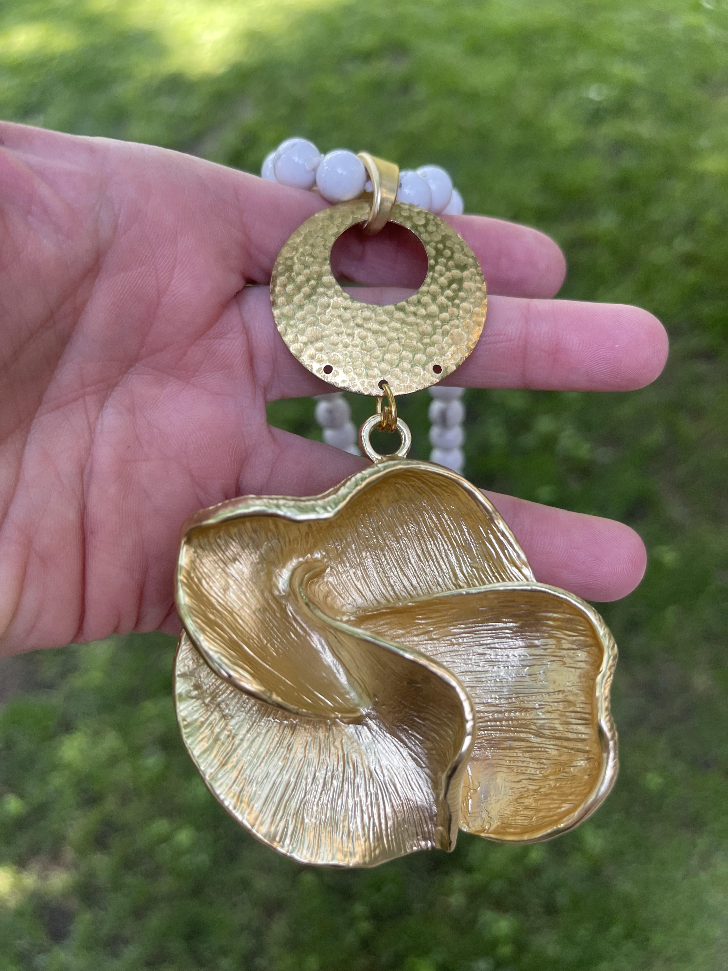 Collar Hippie Chic largo con preciosa flor dorado opaco y piedras naturales blancas anudadas con leves vetas grises.