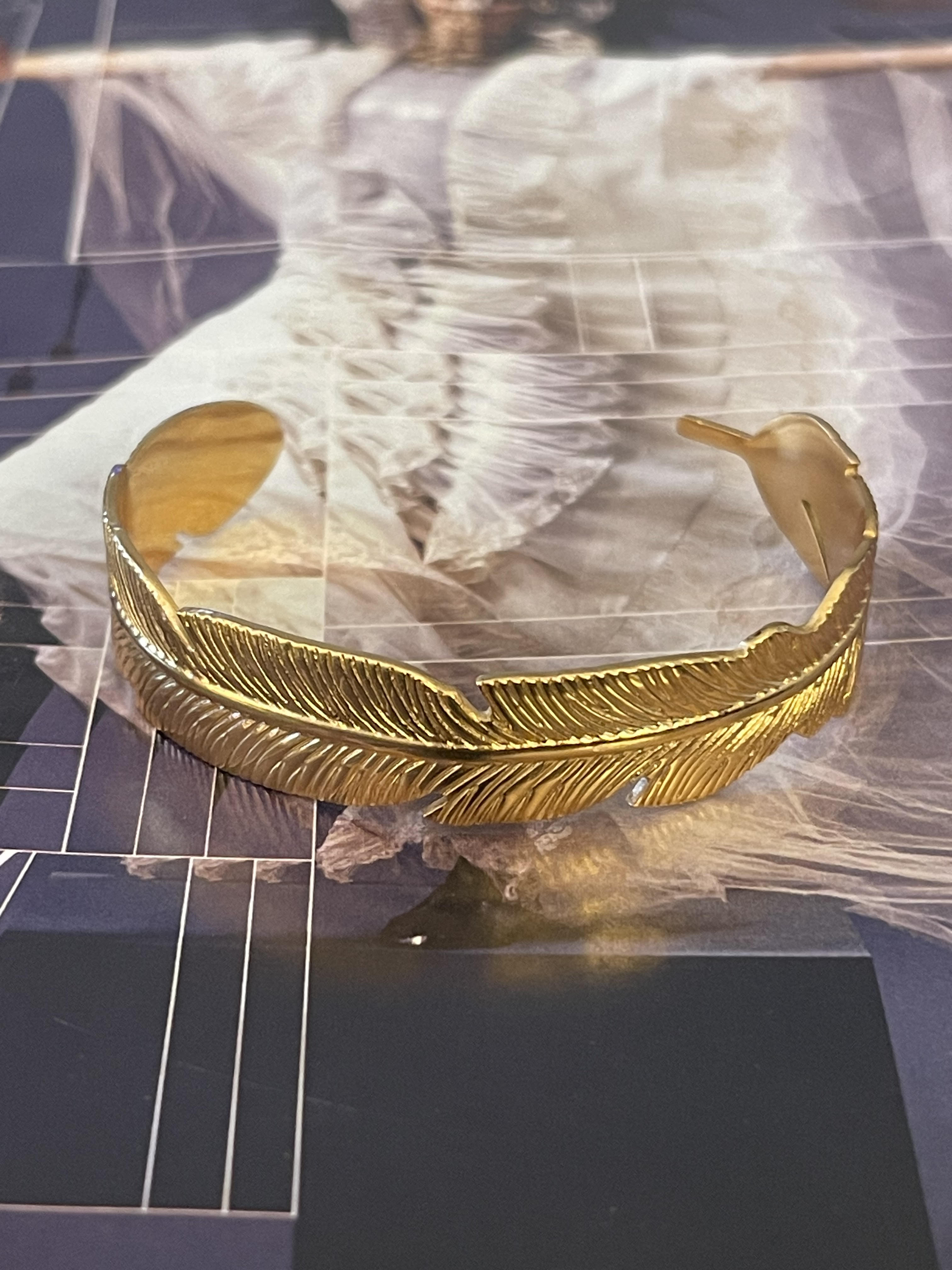 Pulsera Hippie Chic de acero inoxidable dorado con elegante forma de hoja.