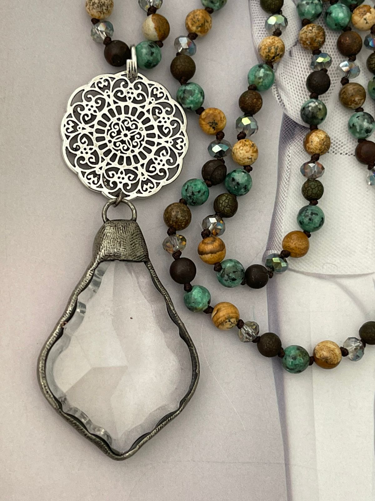 Collar Hippie Chic de piedras y cristales anudados en tonos verdes marrón con colgante de cristal en base plateada.